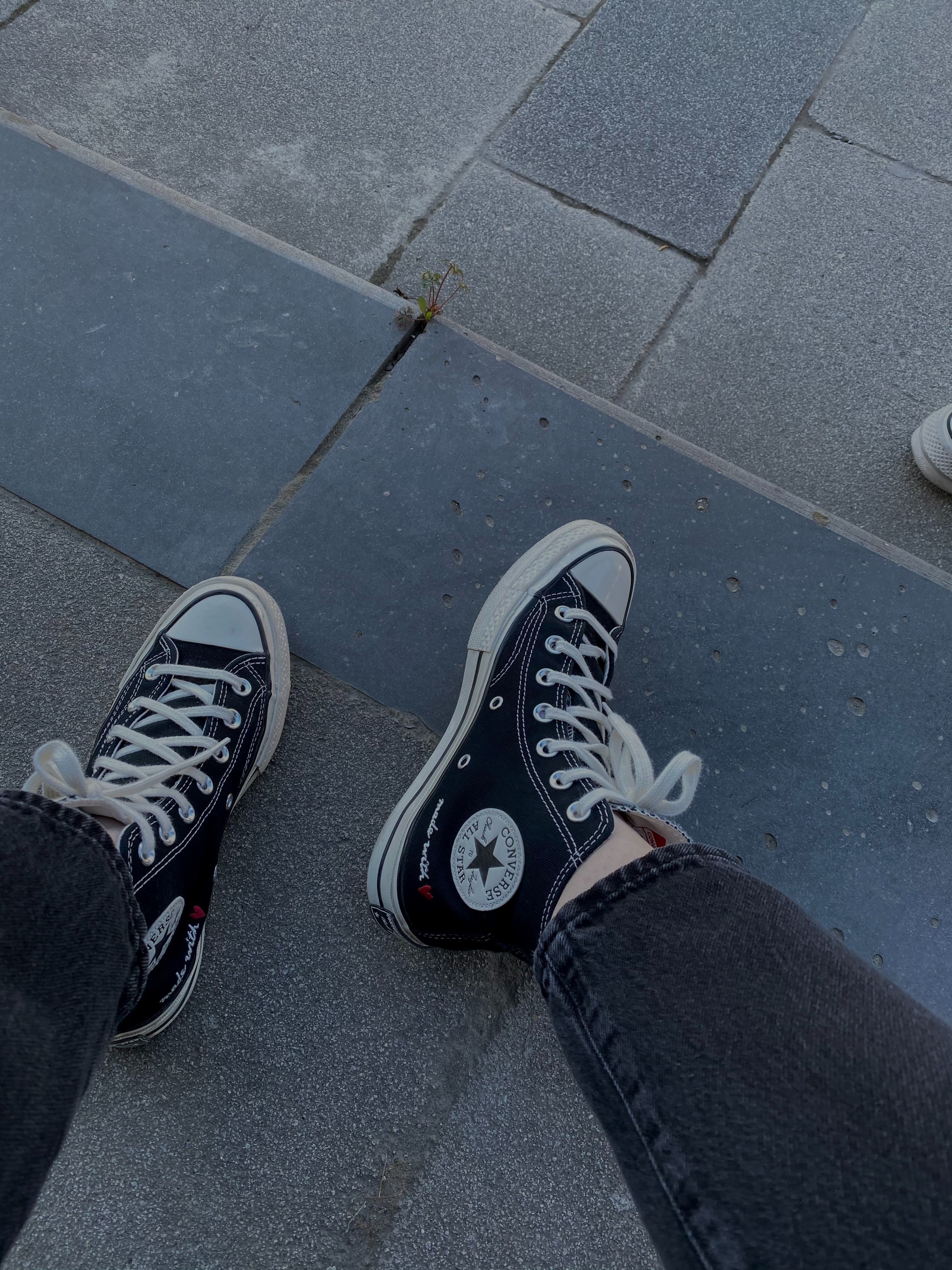 A person wearing black and white sneakers - Shoes, Converse