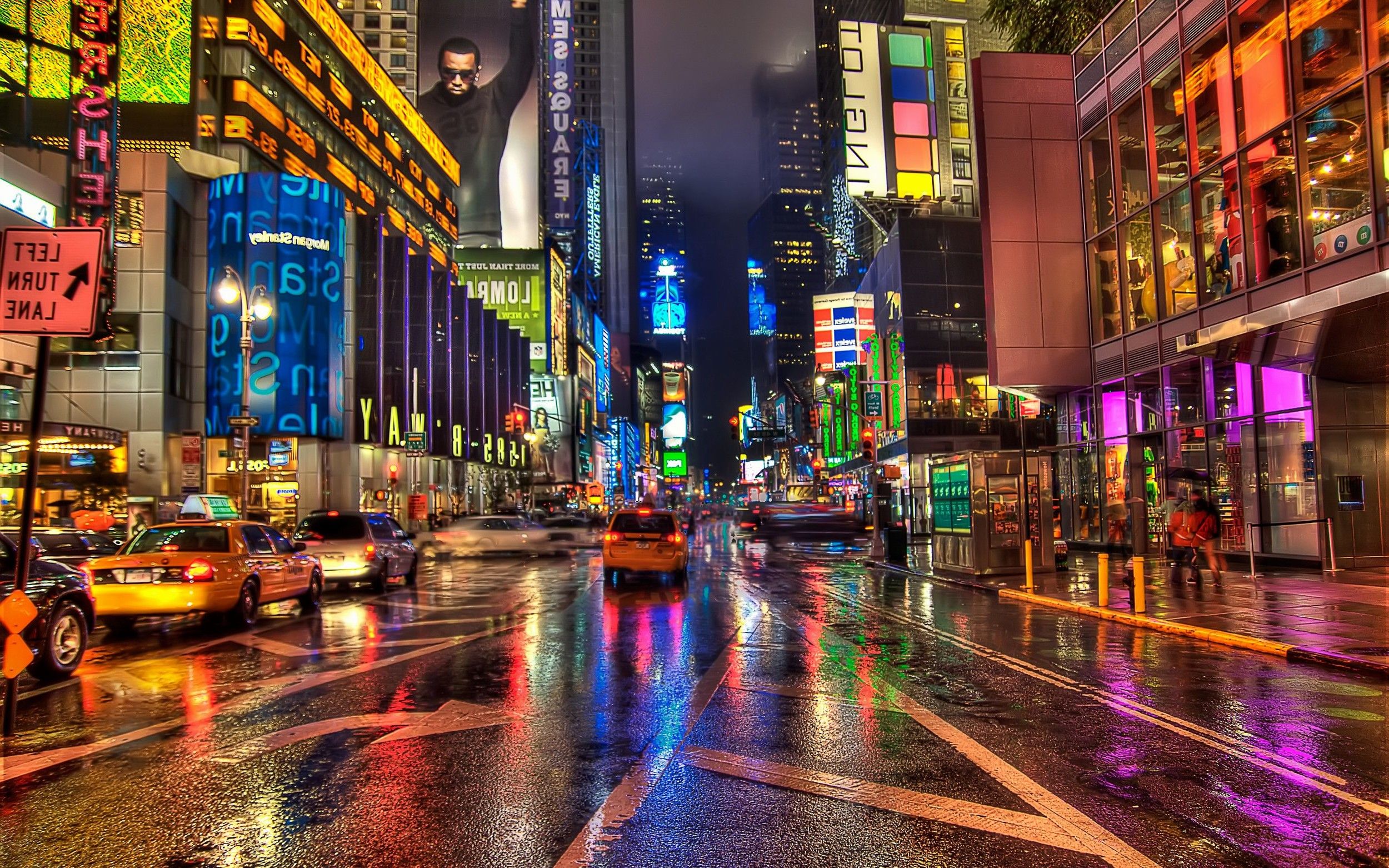 A city street at night with neon lights reflecting off the wet road - Cityscape, New York
