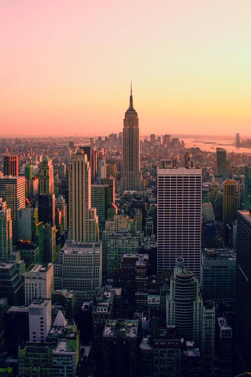 A city skyline at sunset with the empire state building in it - New York, Broadway