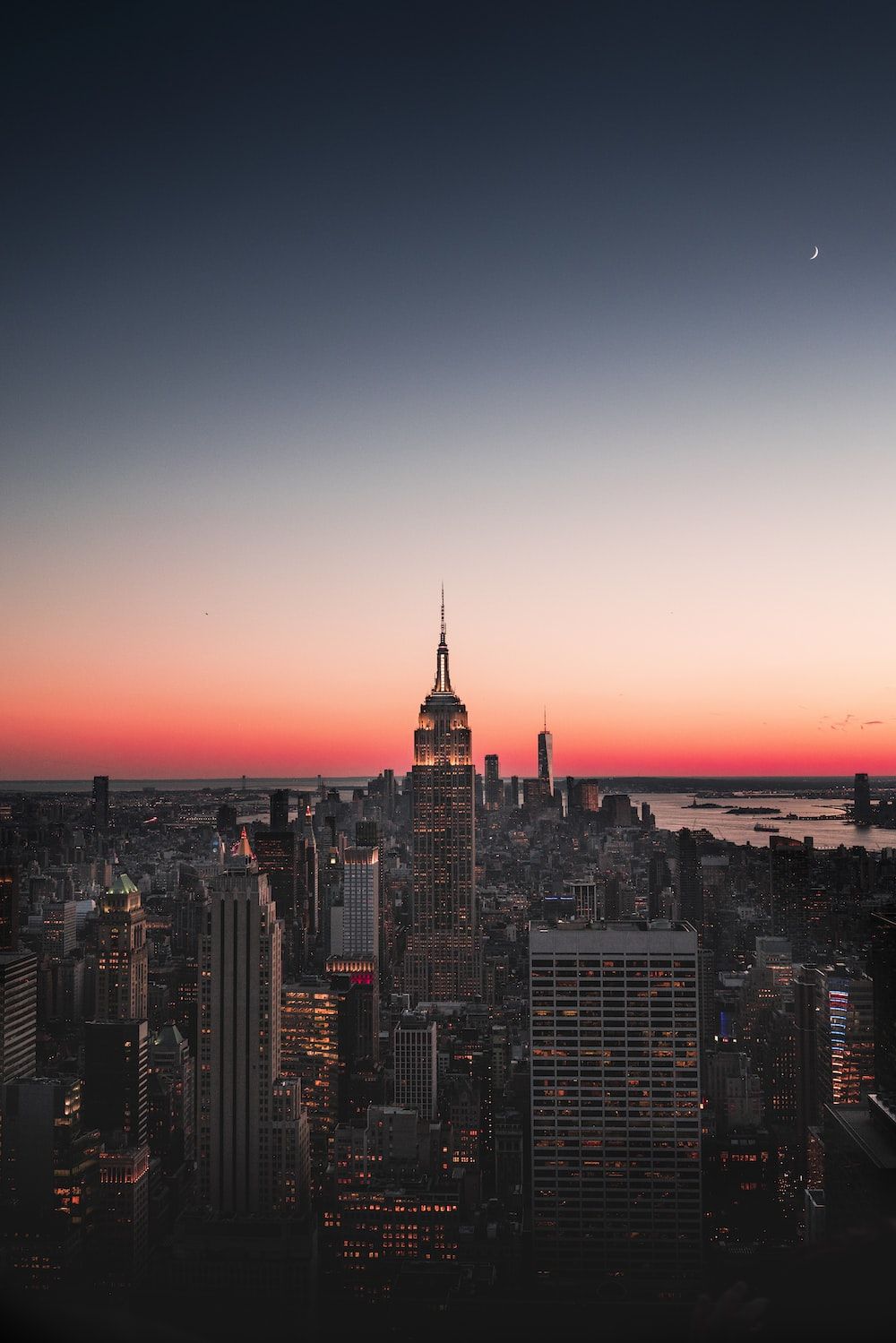 A cityscape at sunset with the moon in the sky. - Sunset, New York, landscape, city