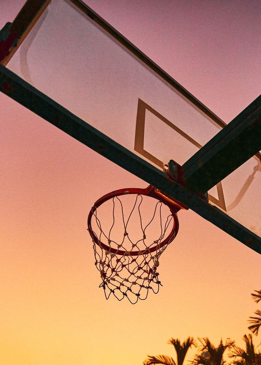 A basketball hoop with the sun setting in background - Basketball