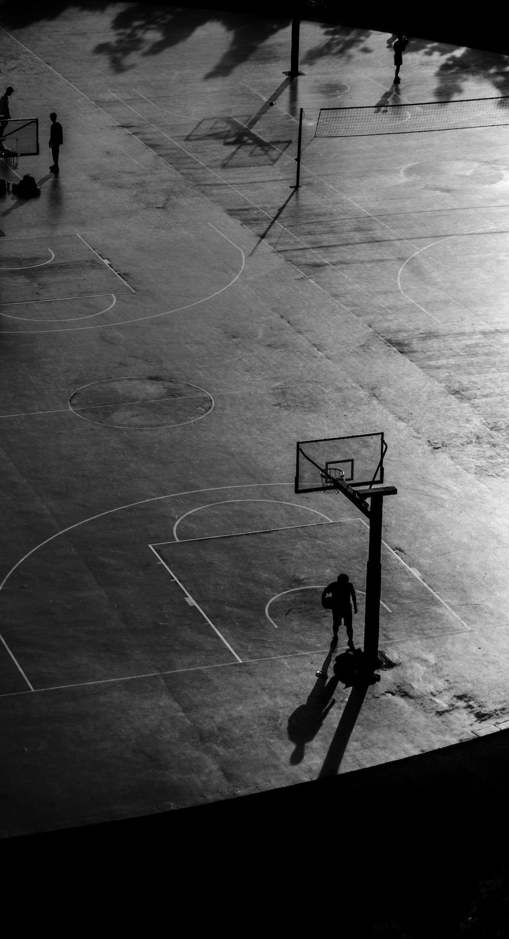 A person playing basketball on a court. - Basketball