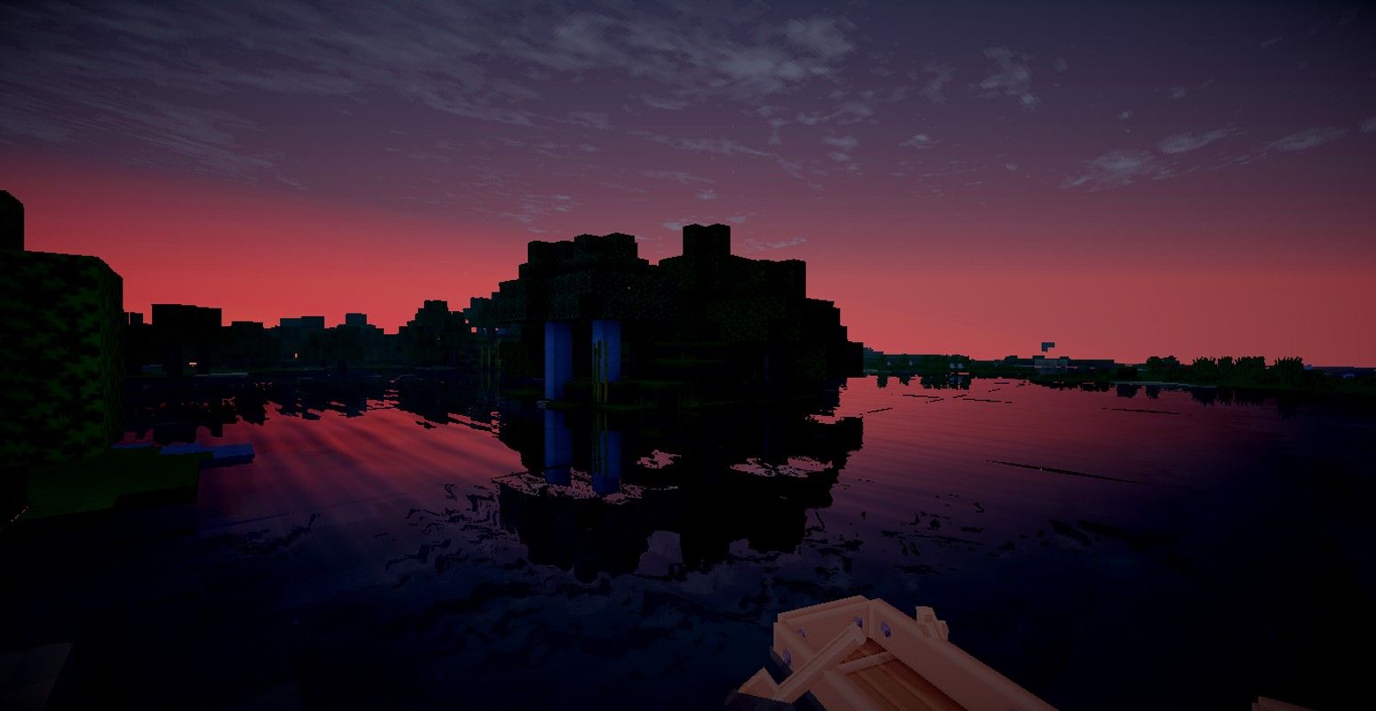 A Minecraft screenshot of a sunset over a small village - Minecraft