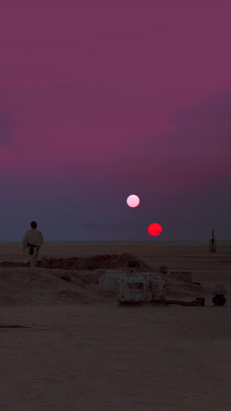 A man in a white outfit stands on a sandy surface with two planets in the sky. - Star Wars