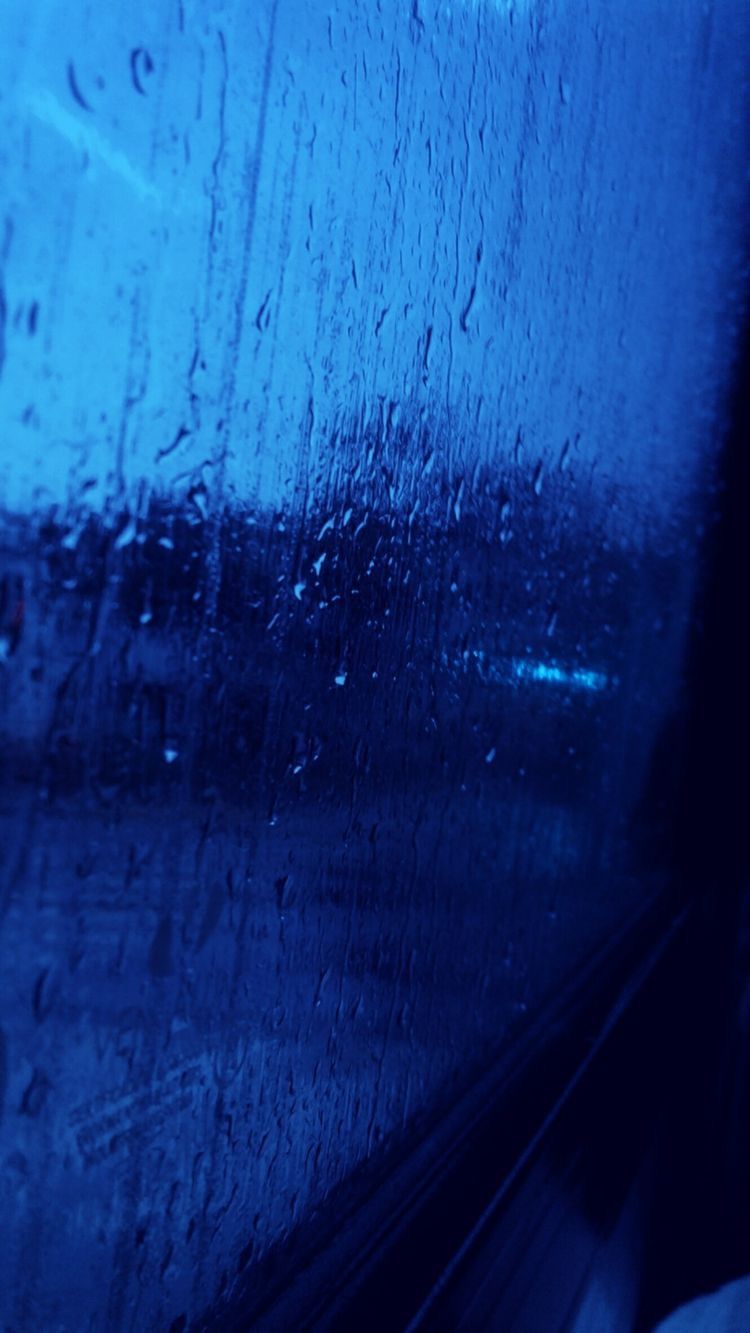 Raindrops on a window with a view of the city - Indigo