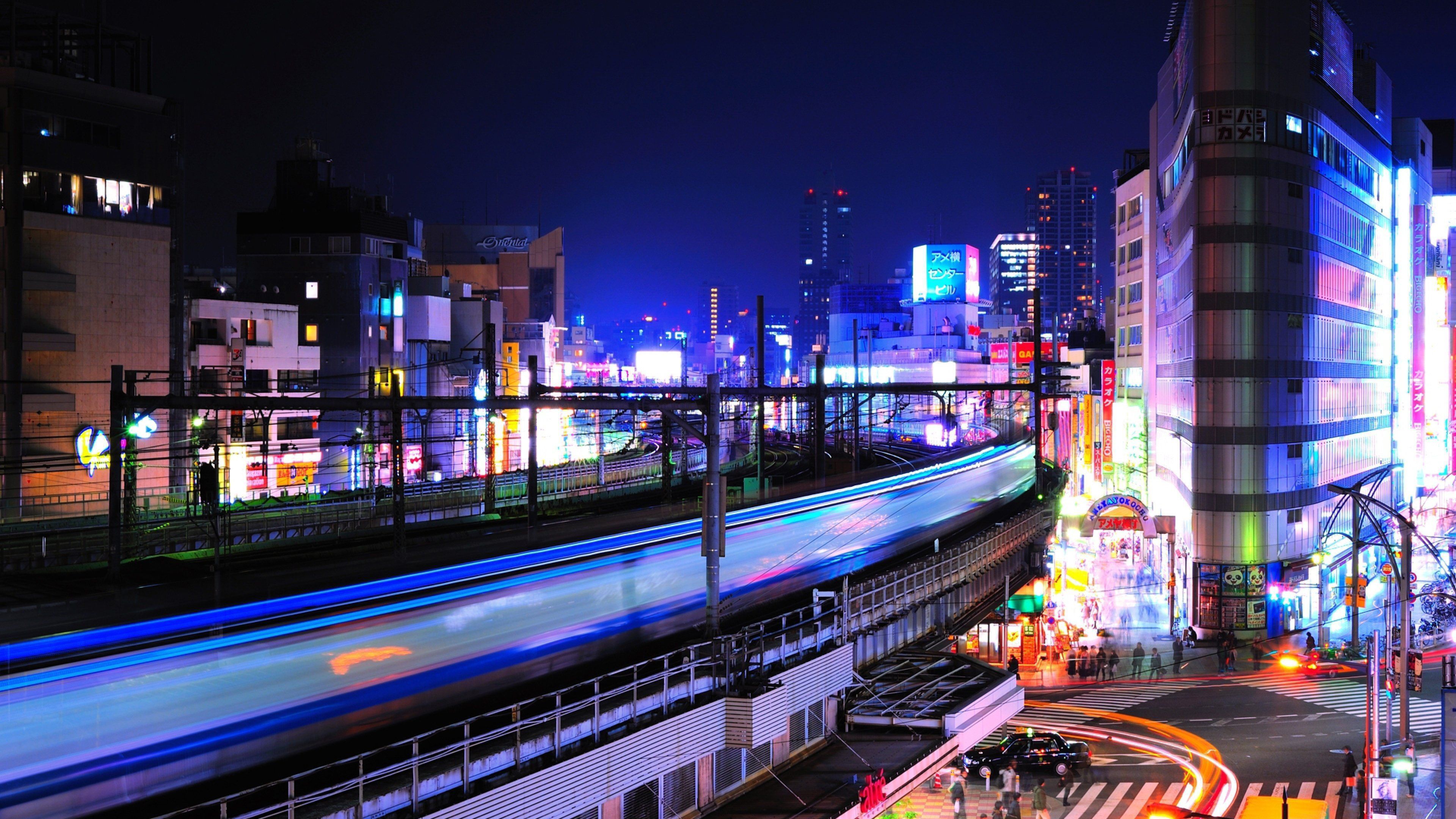 A train passing through a city at night. - Tokyo