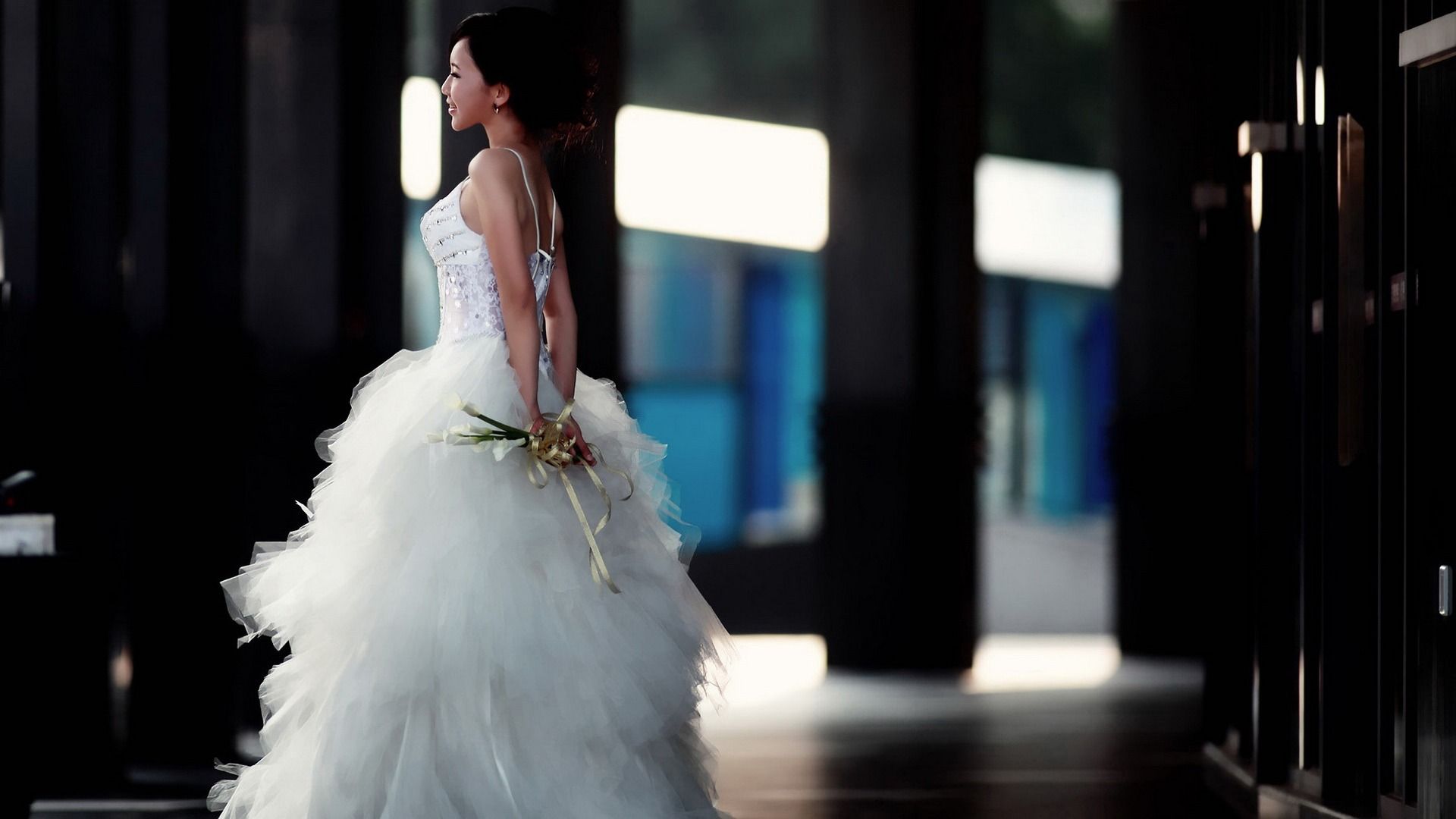 A bride in a white dress holding a bouquet of flowers. - Wedding