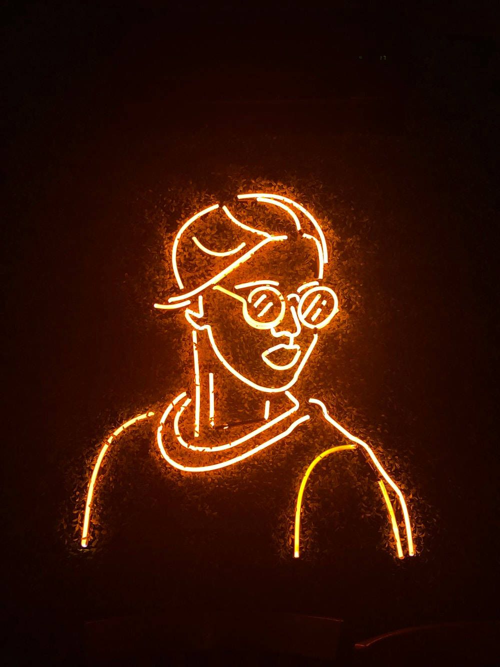 A neon sign of a man with glasses - Dark orange