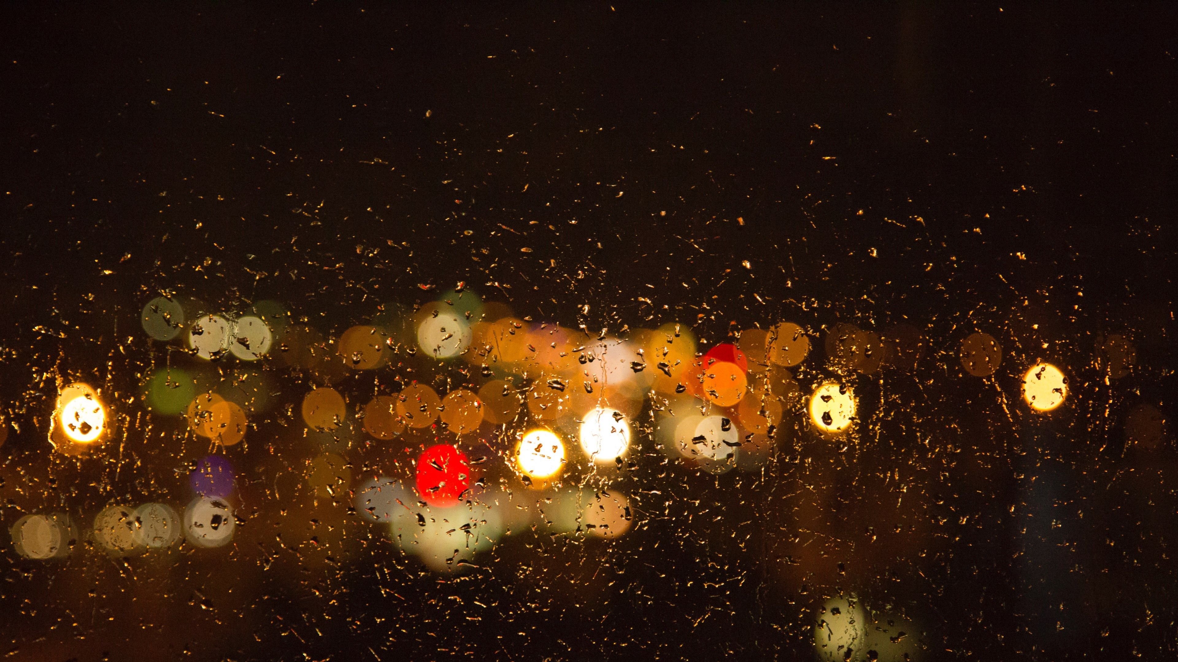 Raindrops on a window with blurred lights in the background - Blurry
