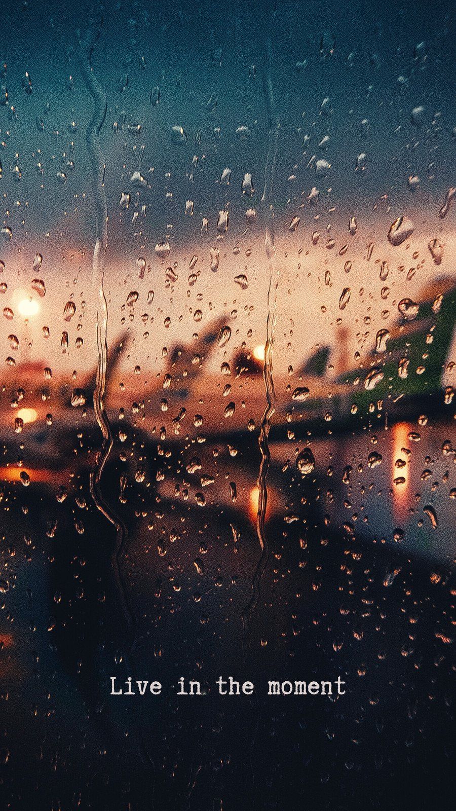 A rain covered window with the words live in this moment - Dark orange, peace