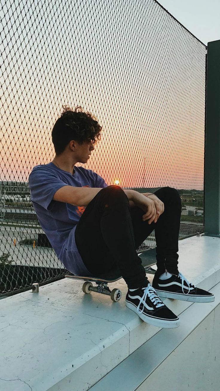 A man sitting on a ledge with a skateboard. - Skate, skater