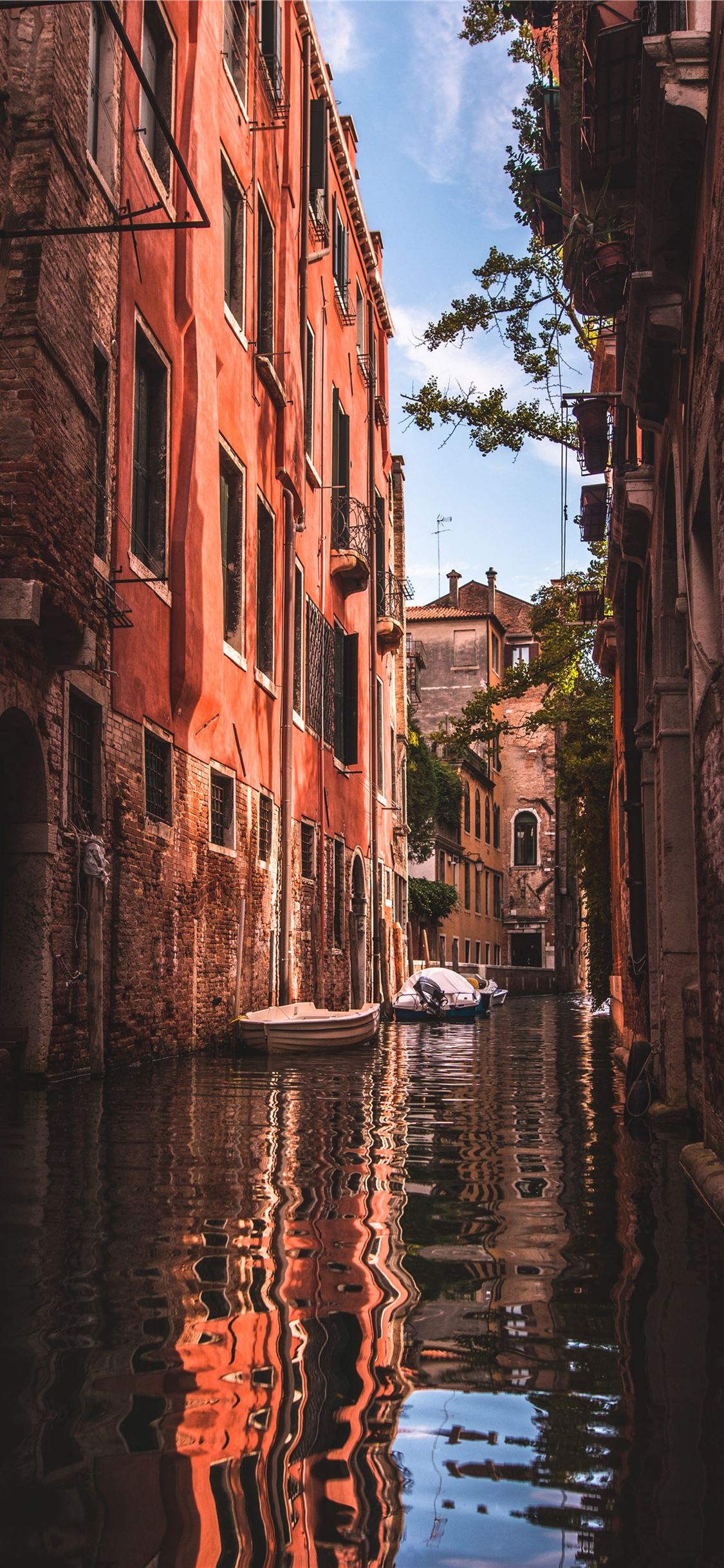 As a canal with boats and buildings - Italy