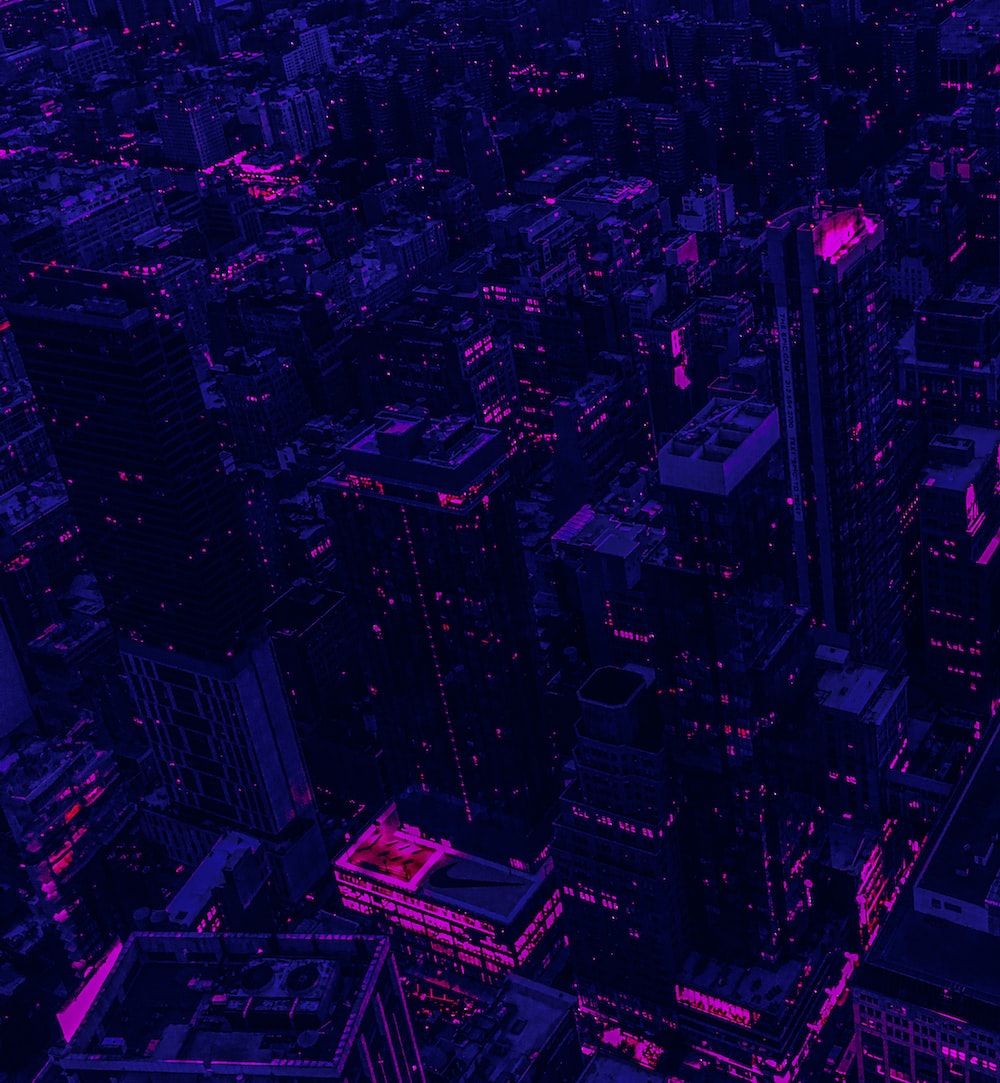 A city at night lit up in purple and pink. - Cyberpunk
