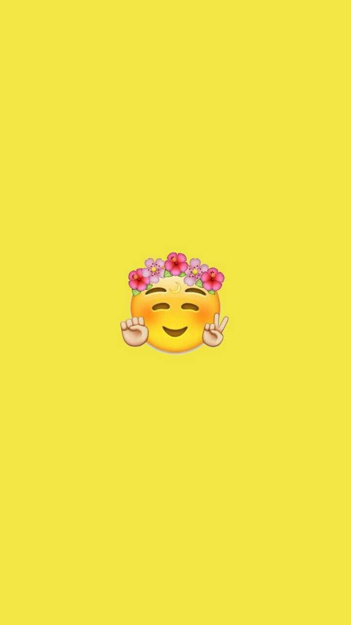 A yellow background with an emoji face wearing flowers - Emoji