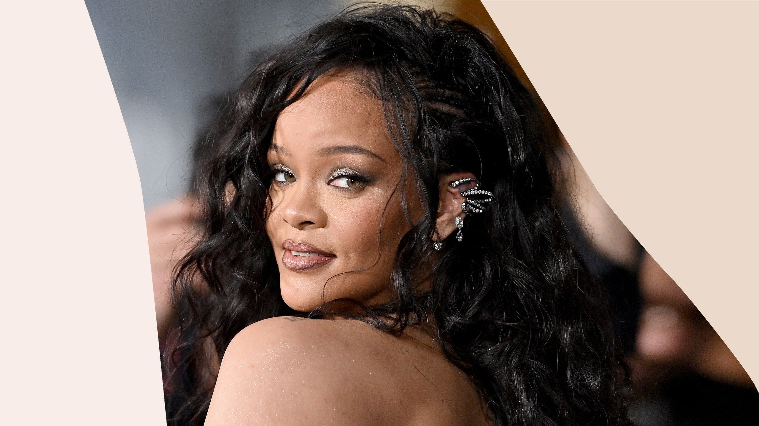 Rihanna turns her head to the side with her curly hair and silver eye makeup on - Rihanna