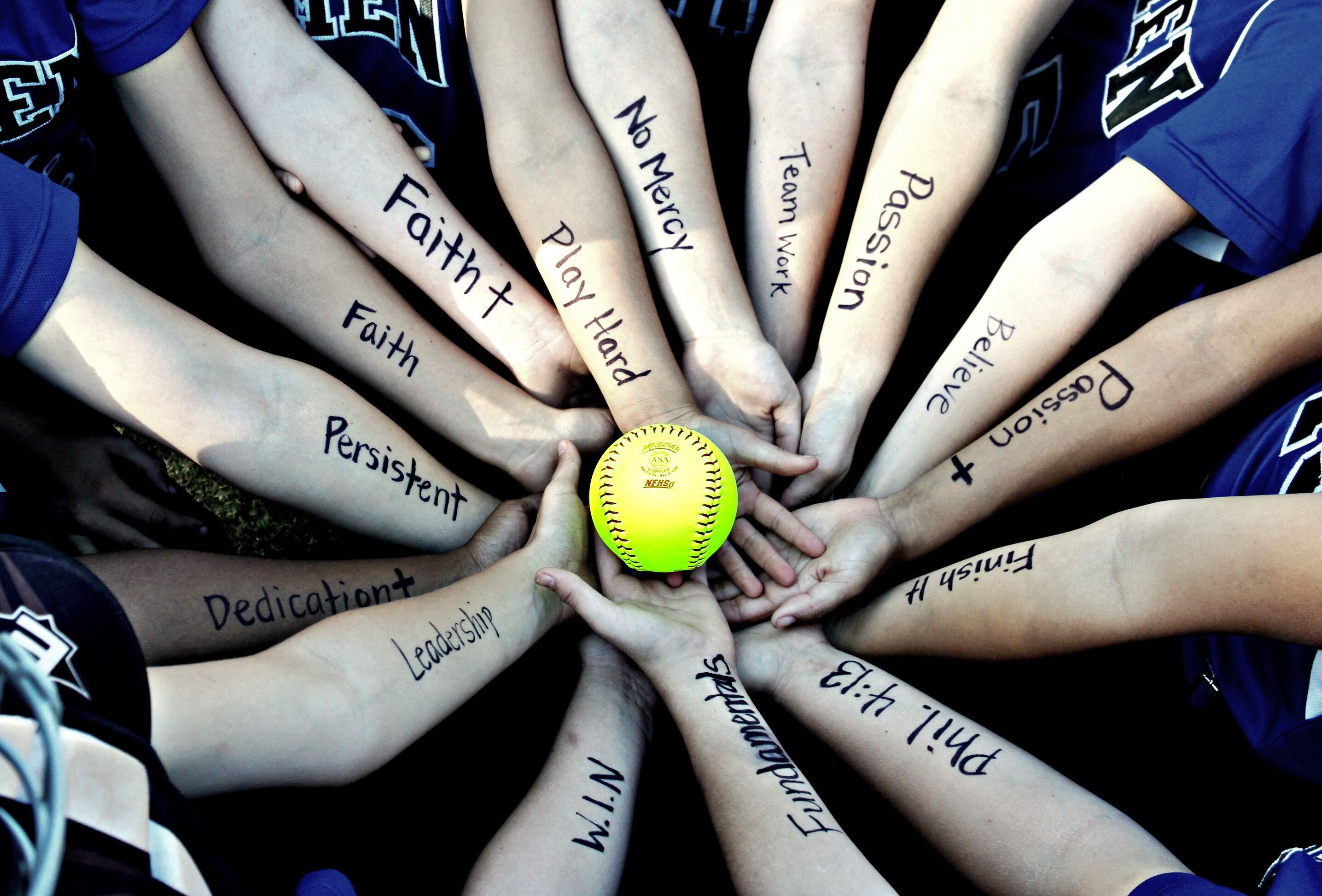 Softball players with inspirational words written on their arms - Softball