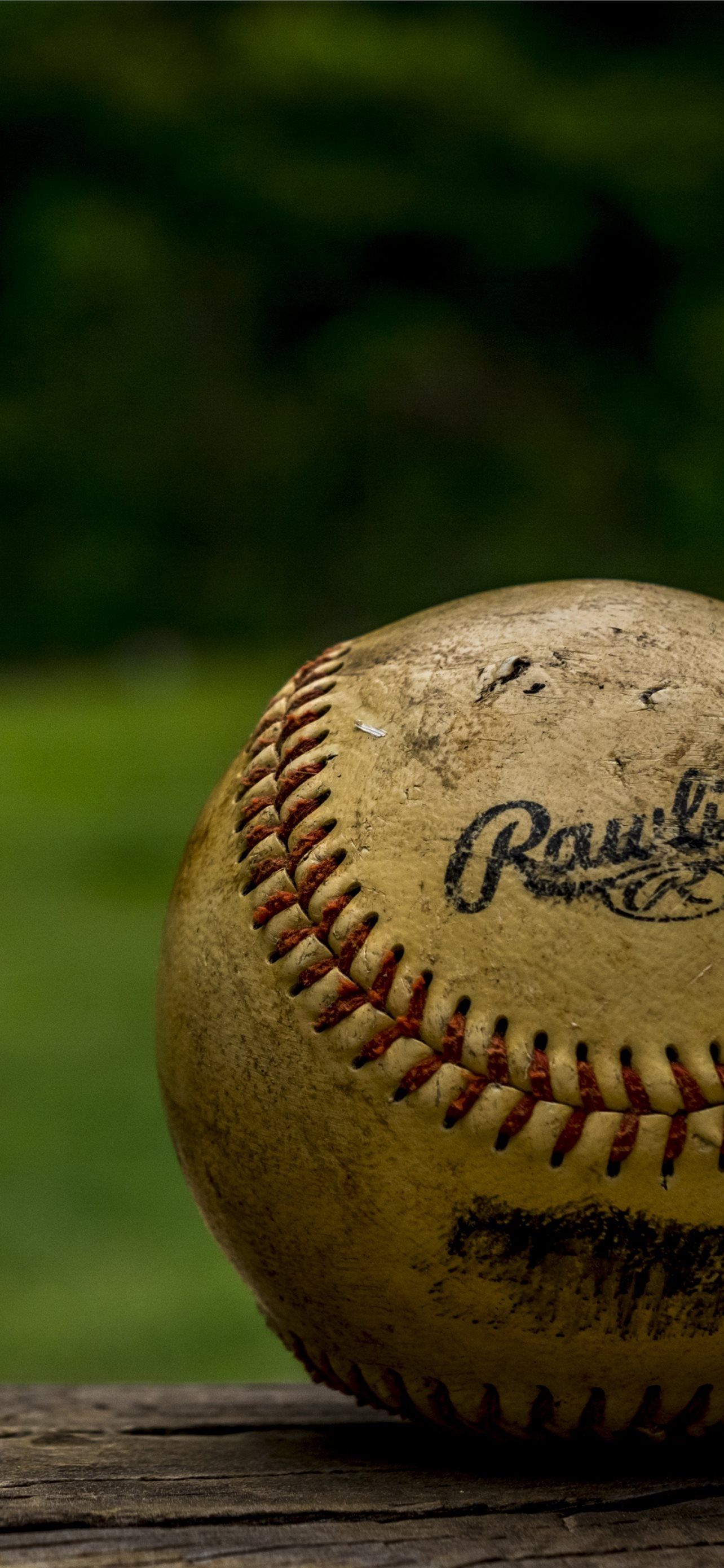 A baseball sitting on top of wood - Softball