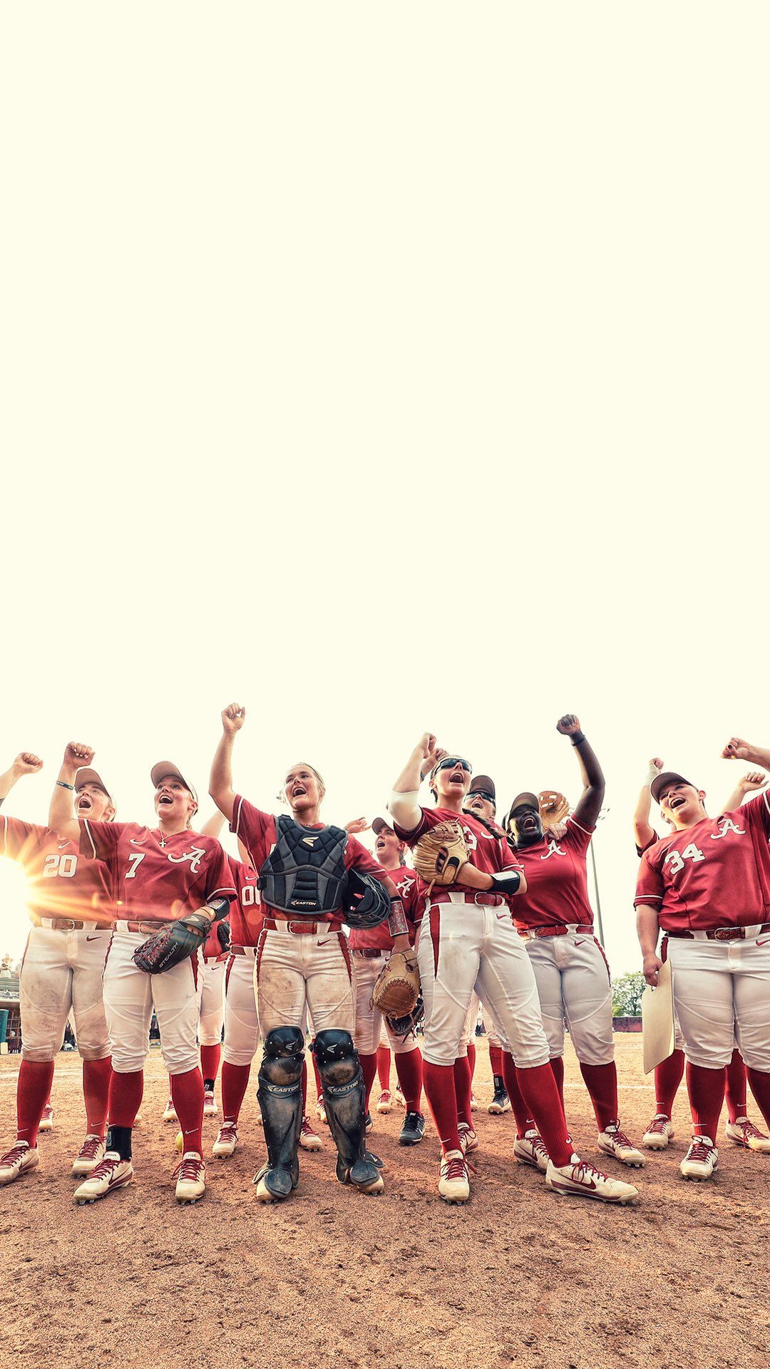 A team of softball players on a field, celebrating. - Softball