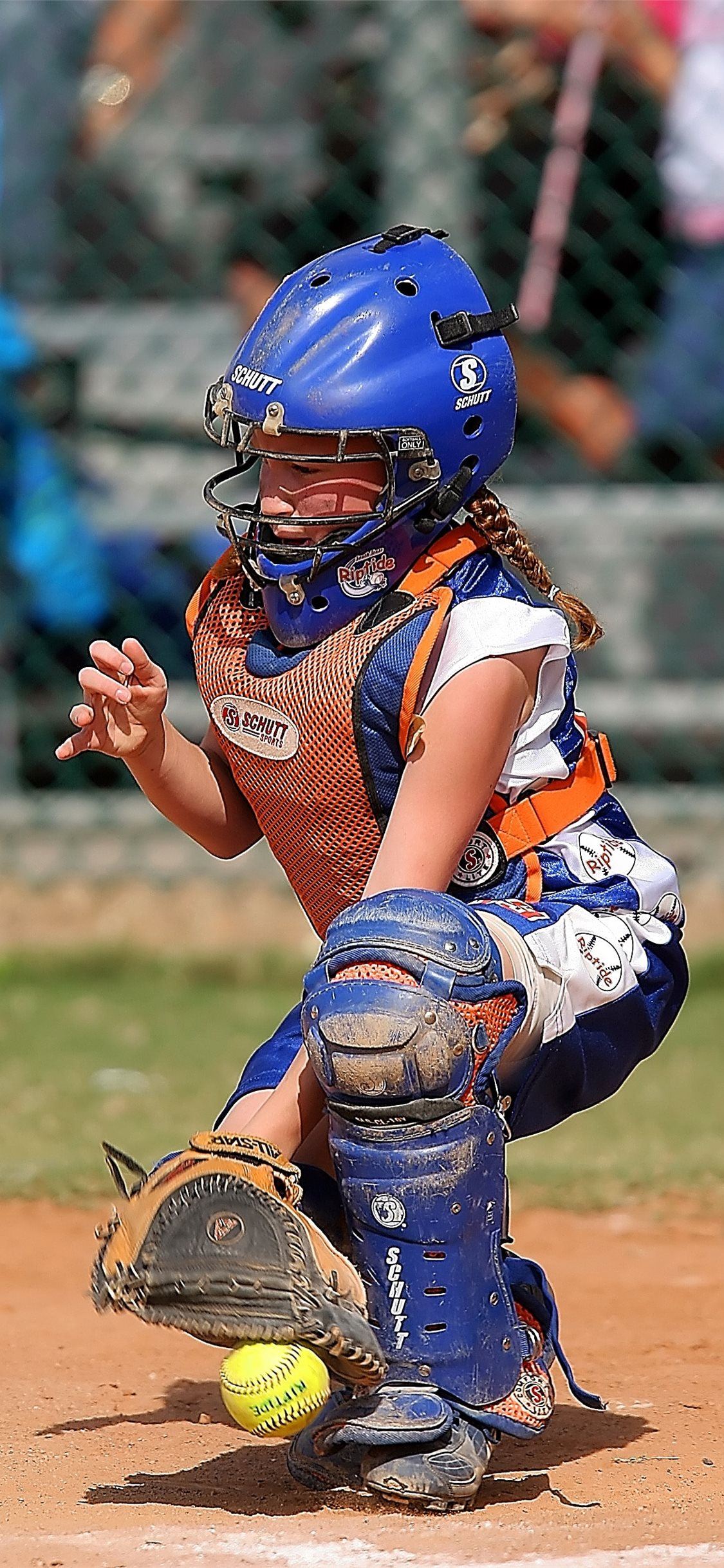 A young girl playing softball in her catcher gear - Softball