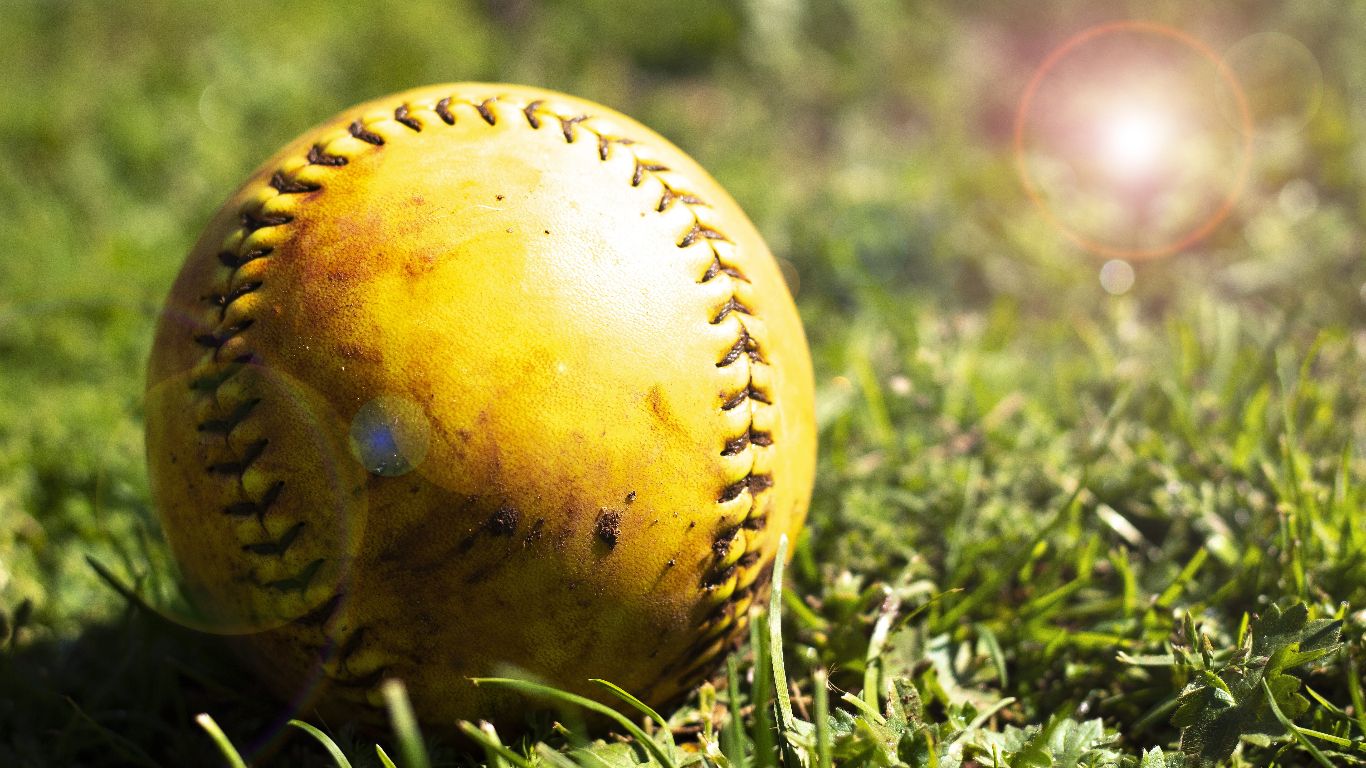 A baseball is sitting on top of some grass - Softball