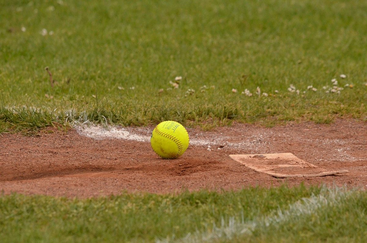 A softball that is on the ground - Softball