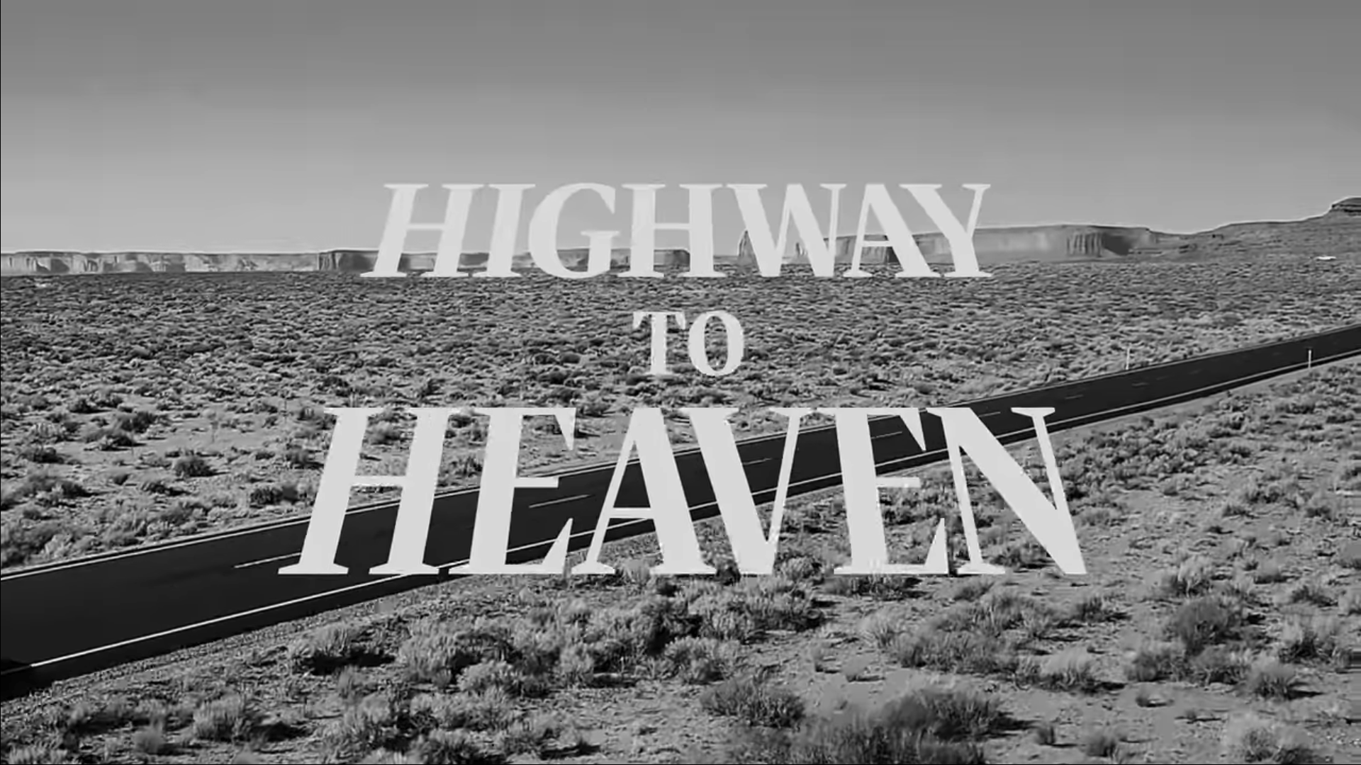 A black and white image of a highway in the desert with the words 