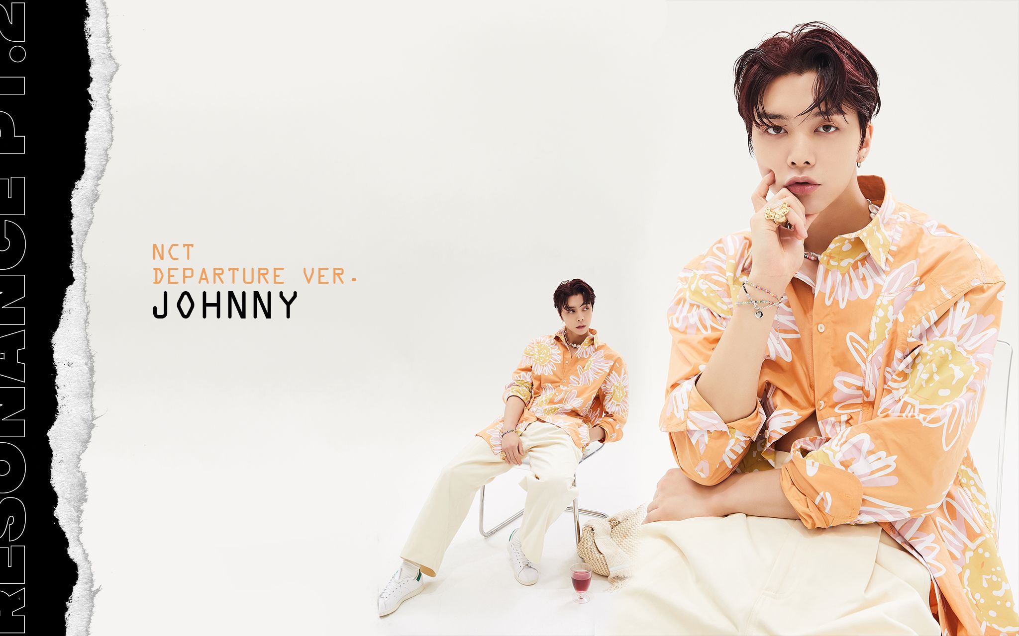 Johnny is sitting on a chair with his legs crossed and looking at the camera. He is wearing a yellow shirt and white pants. - NCT