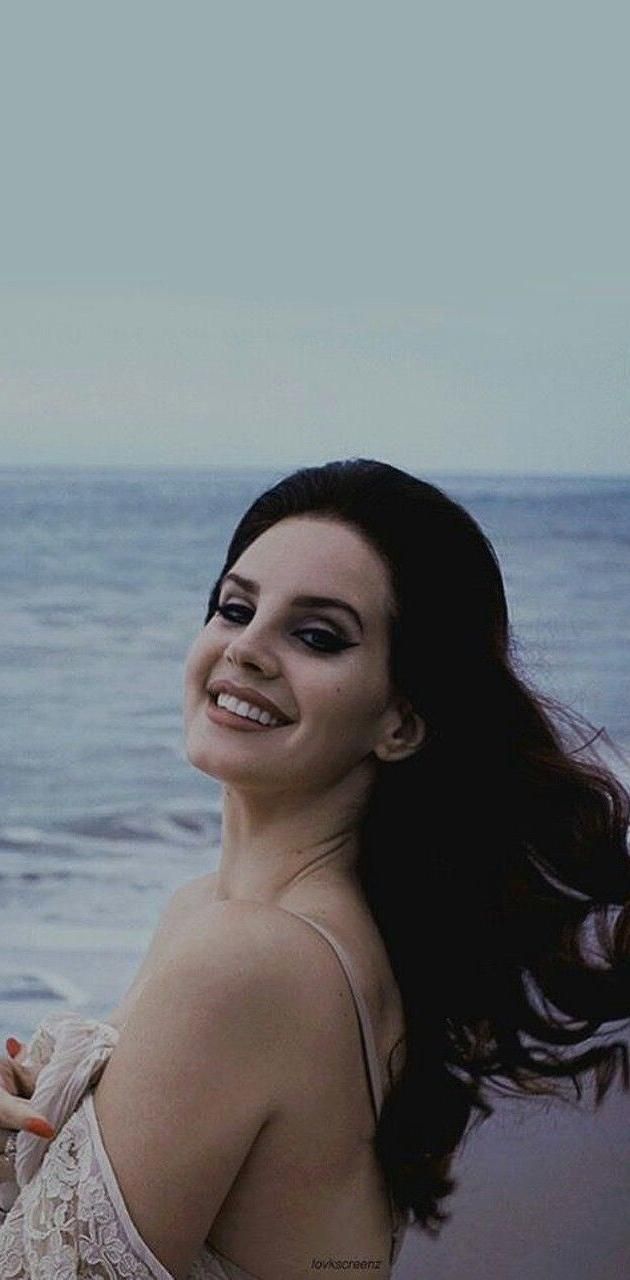 A woman is standing on the beach - Lana Del Rey