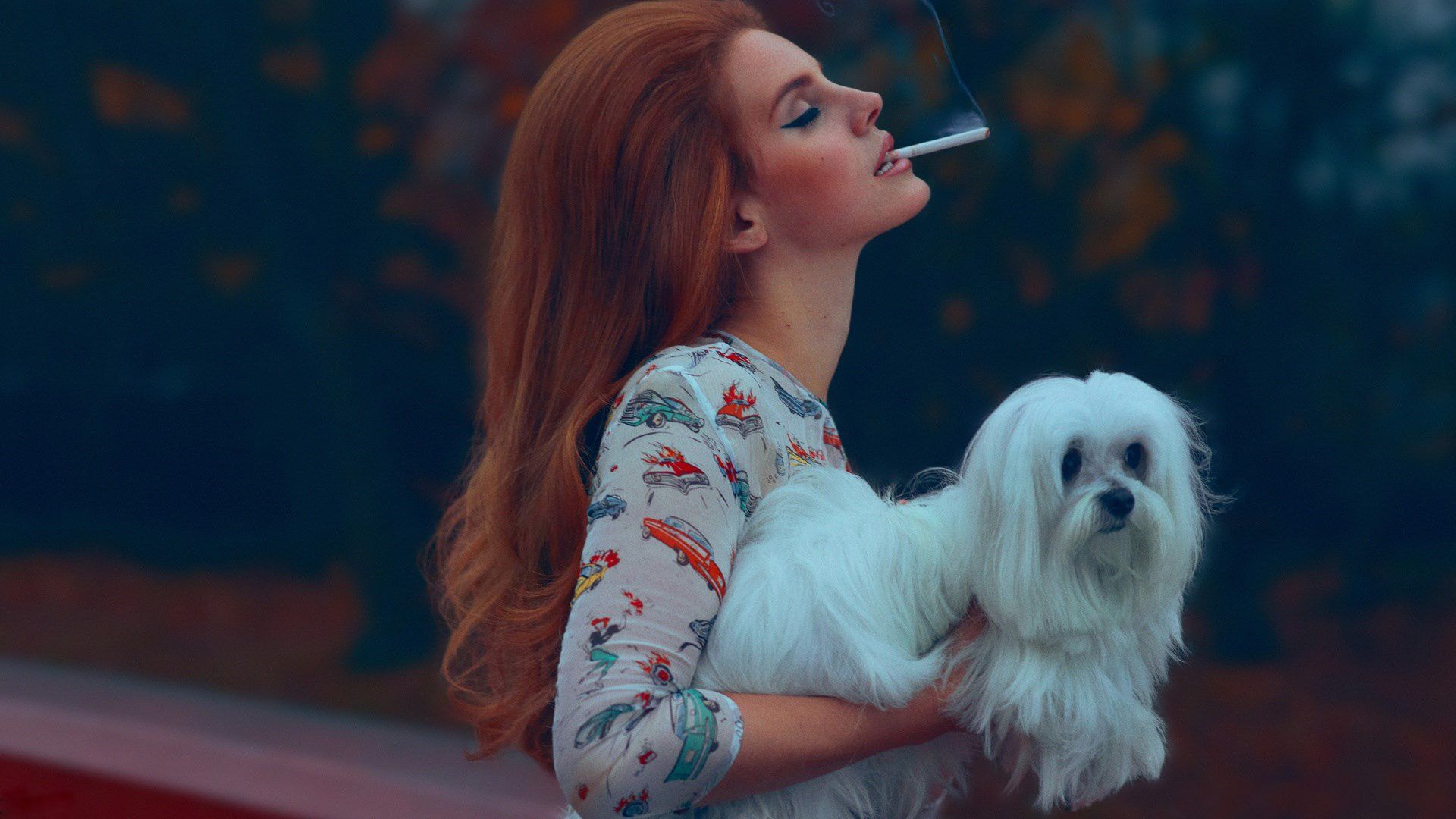 A woman holding her dog while smoking - Lana Del Rey
