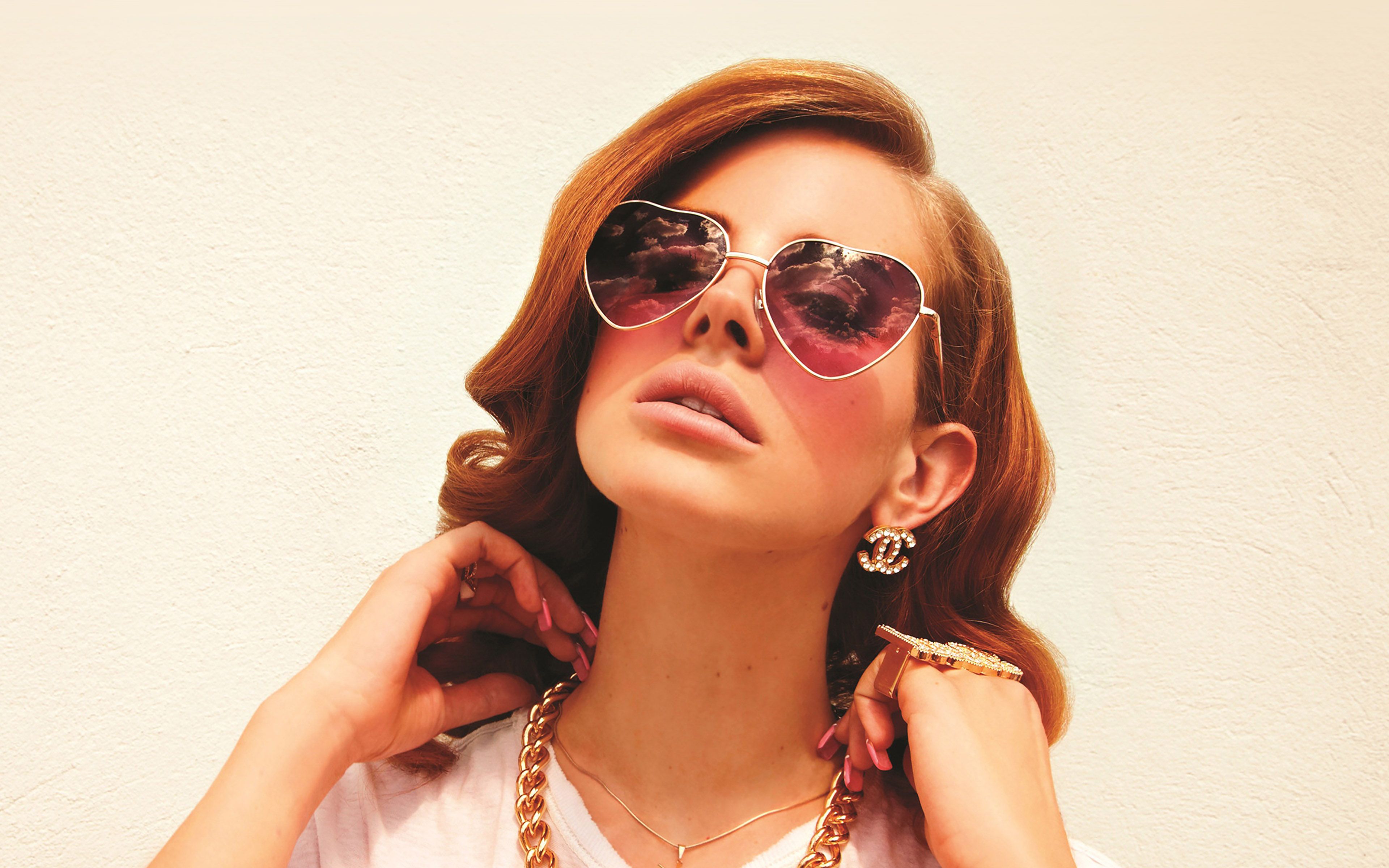 Close up of a woman wearing sunglasses and gold jewelry - Lana Del Rey