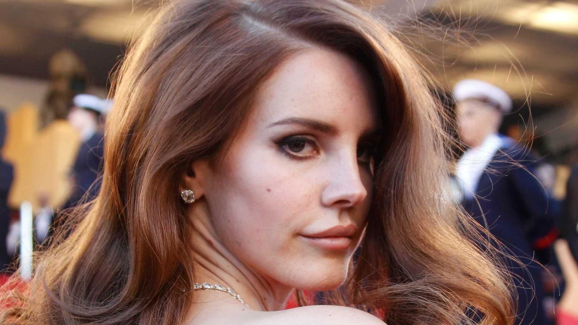 A woman with long hair and earrings - Lana Del Rey