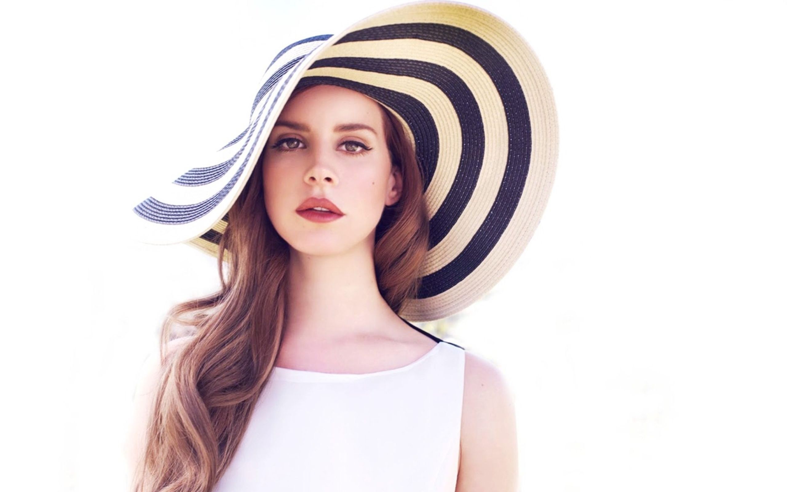 A woman wearing an oversized hat and white dress - Lana Del Rey