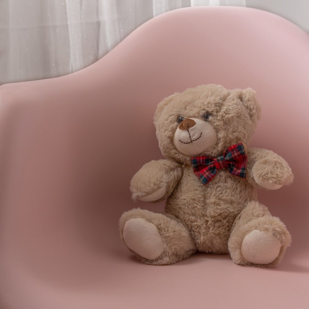 A teddy bear sitting in an arm chair - Teddy bear