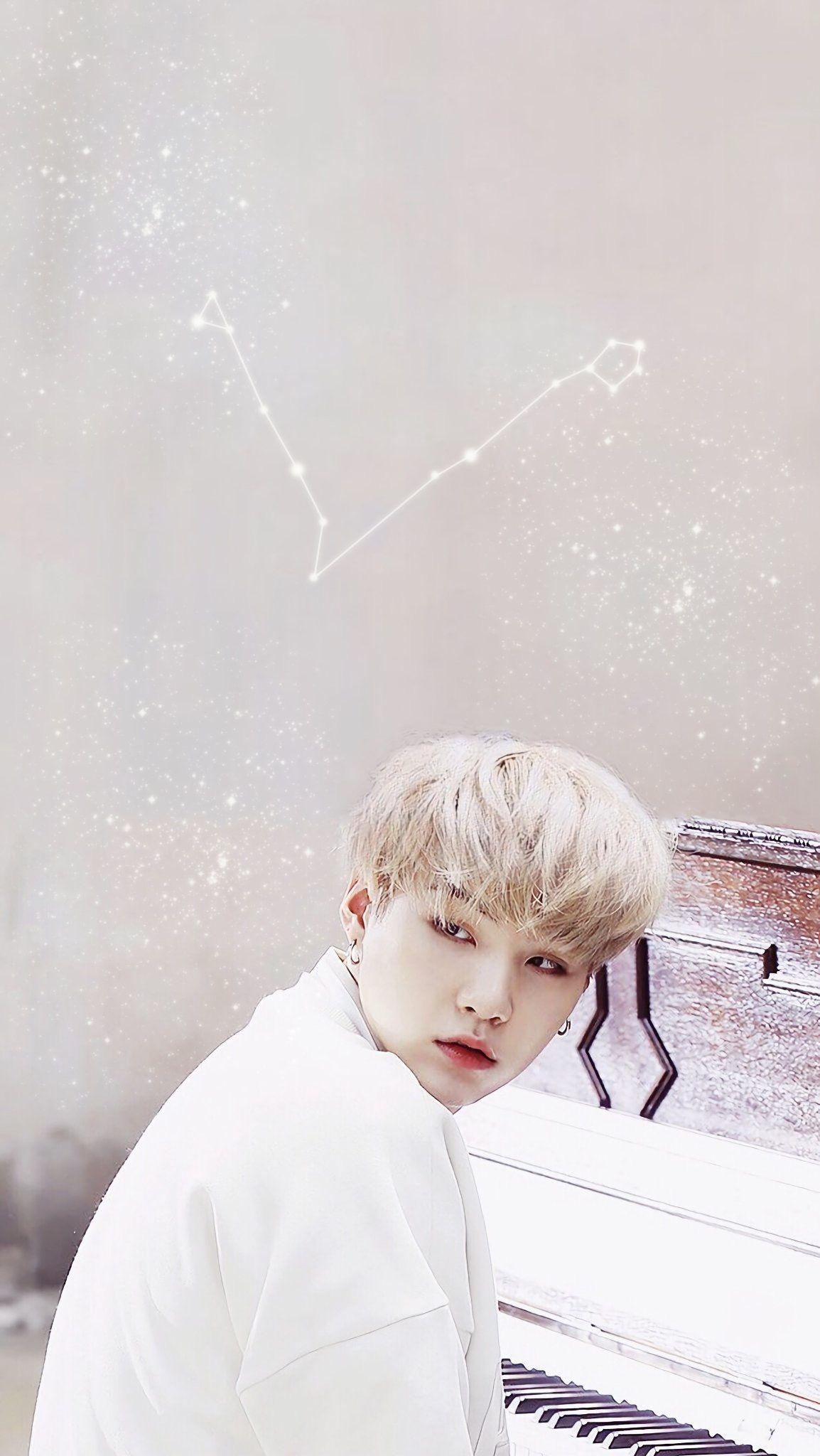 A man sitting at the piano with stars in his hair - BTS