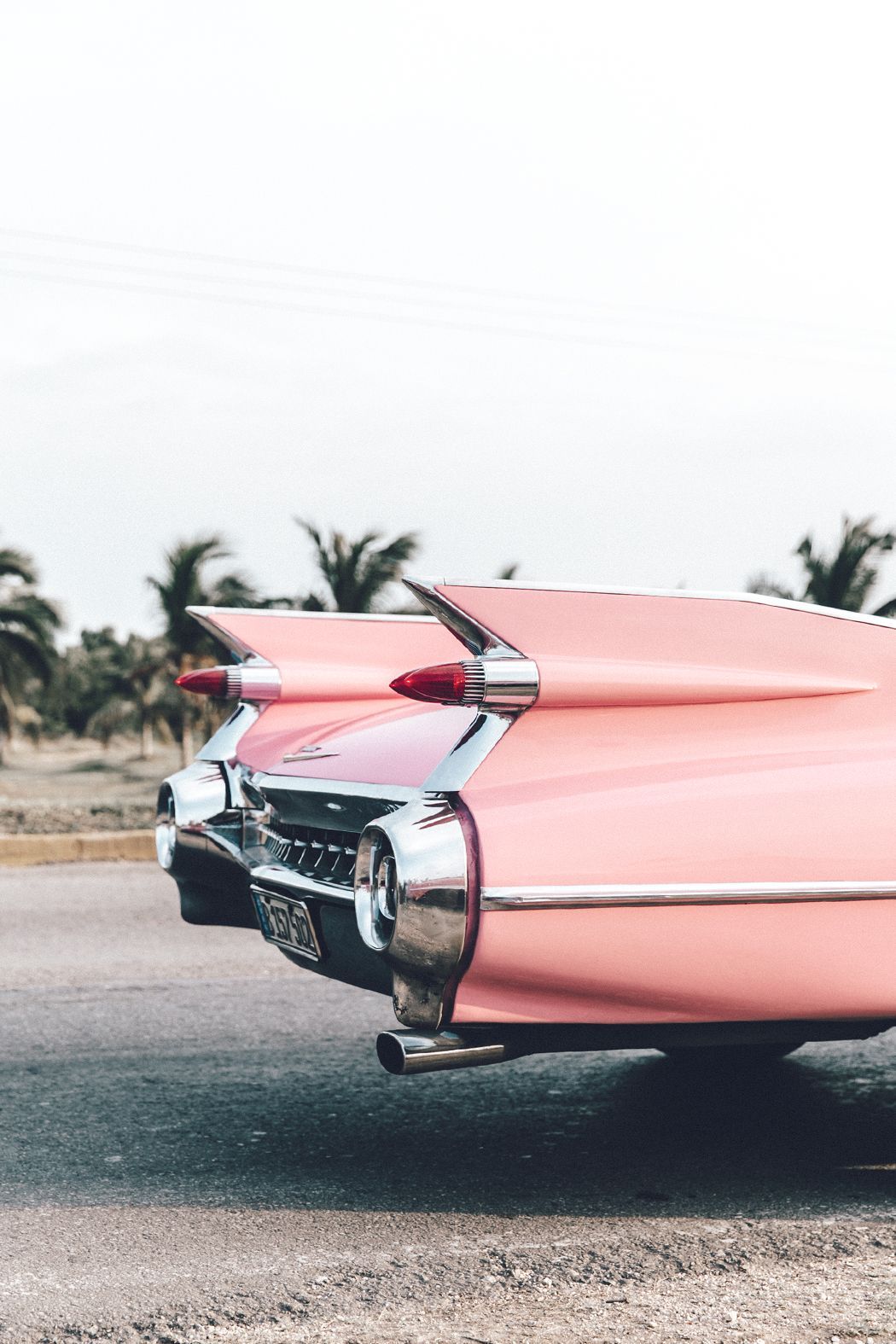 A pink car is parked on the side of road - Vintage