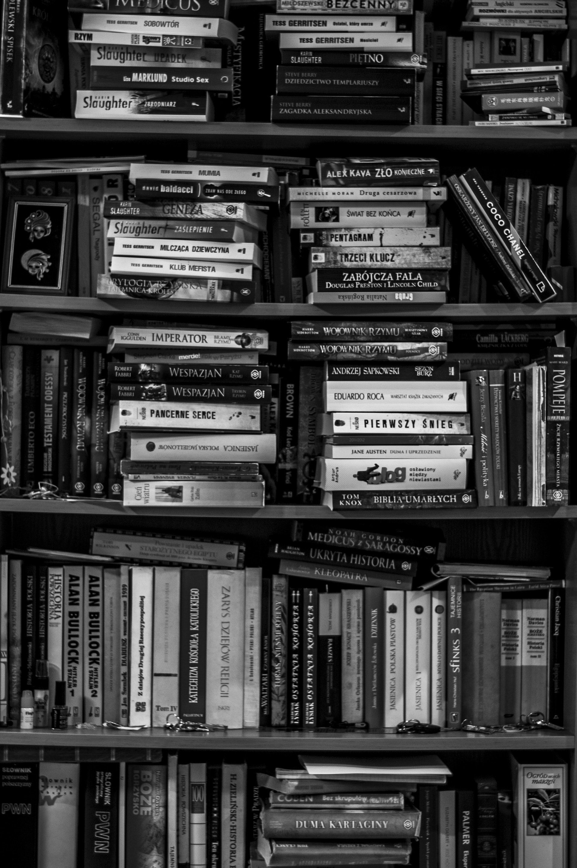 A black and white photo of books on shelves - Bookshelf, books, library