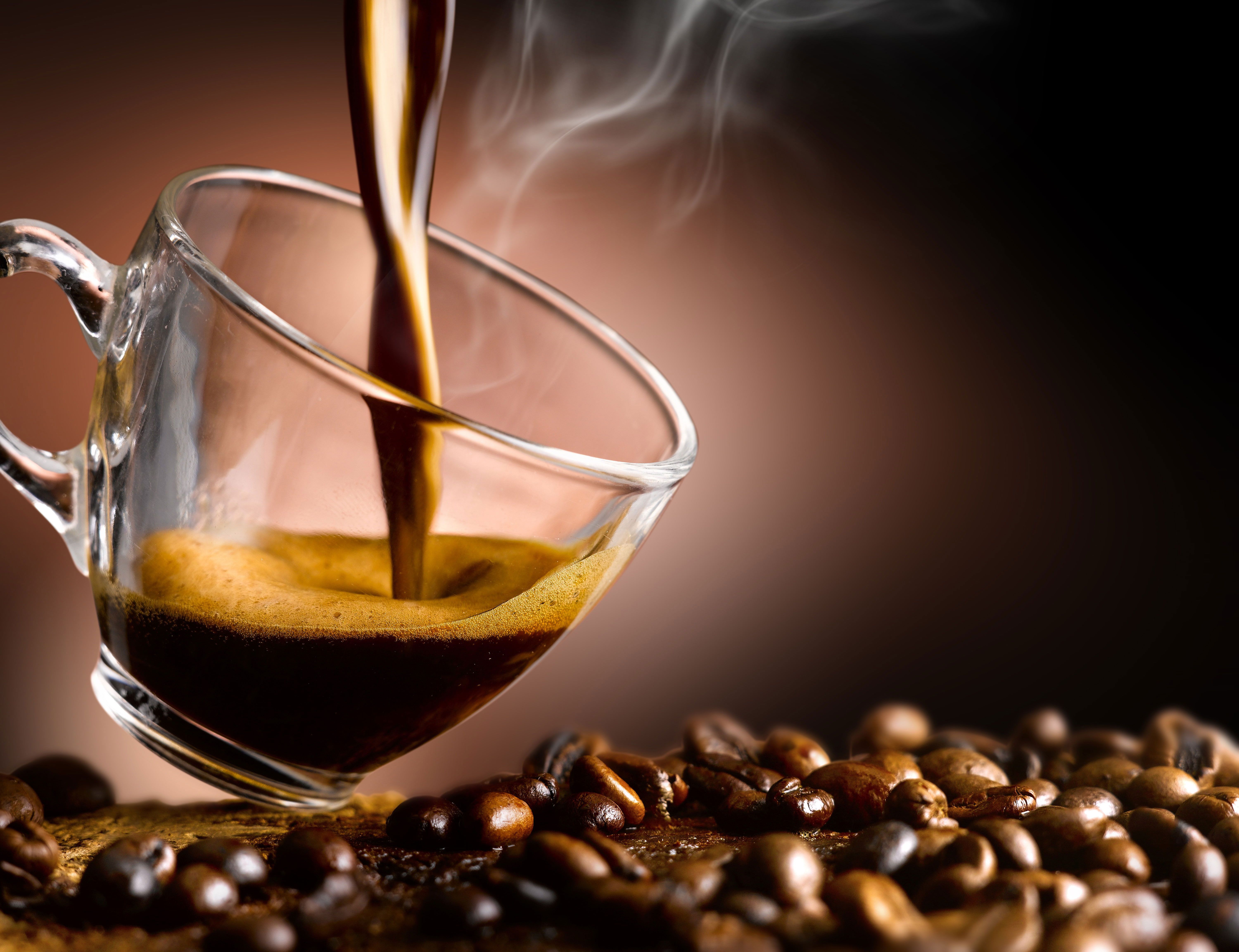 A cup of coffee being poured into another glass - Coffee