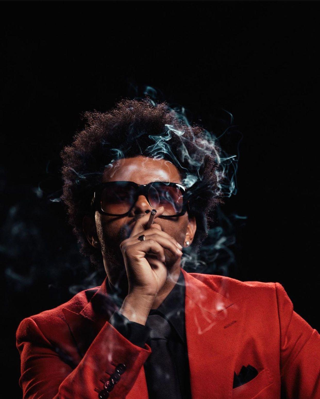 A man in red suit smoking cigarette - The Weeknd