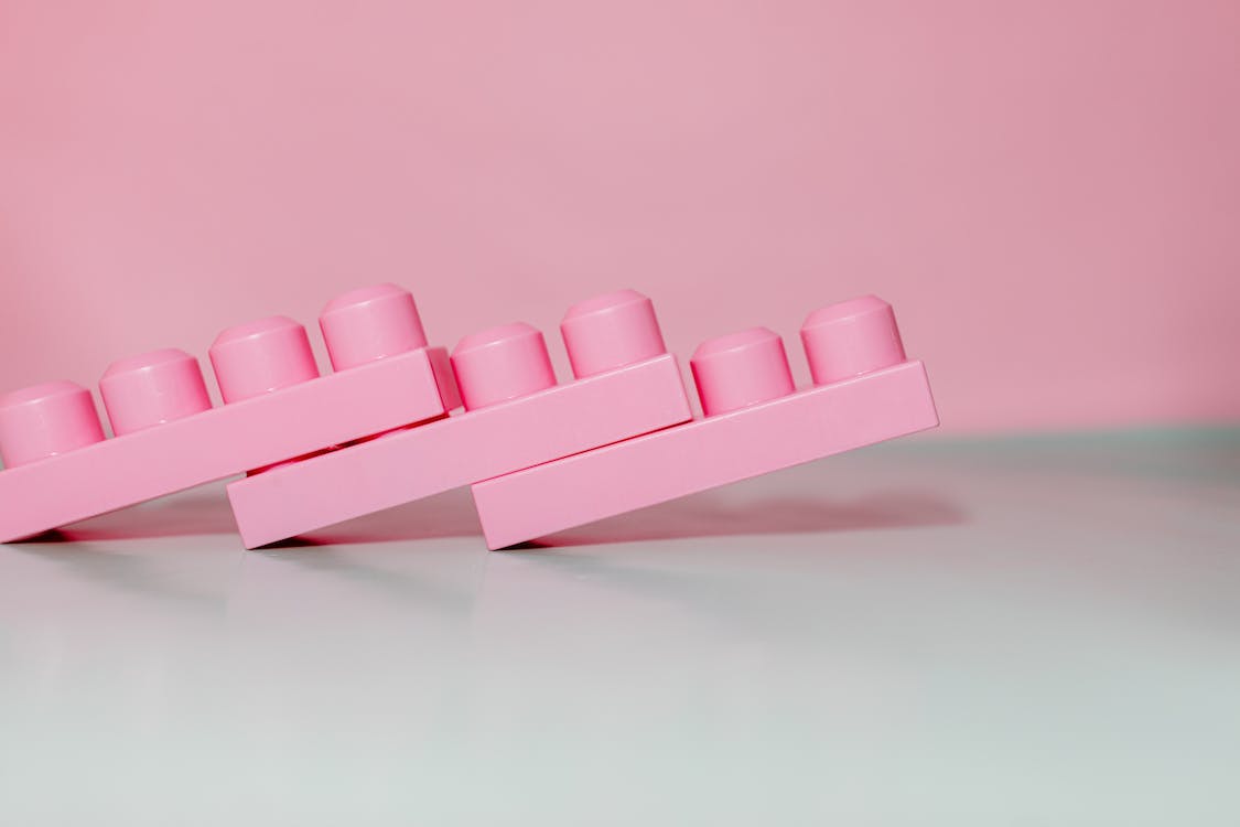 A pink lego brick is on the table - 90s