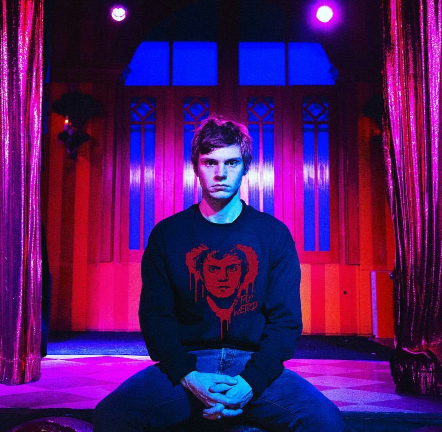 A man sitting on the floor in front of an arch - Evan Peters