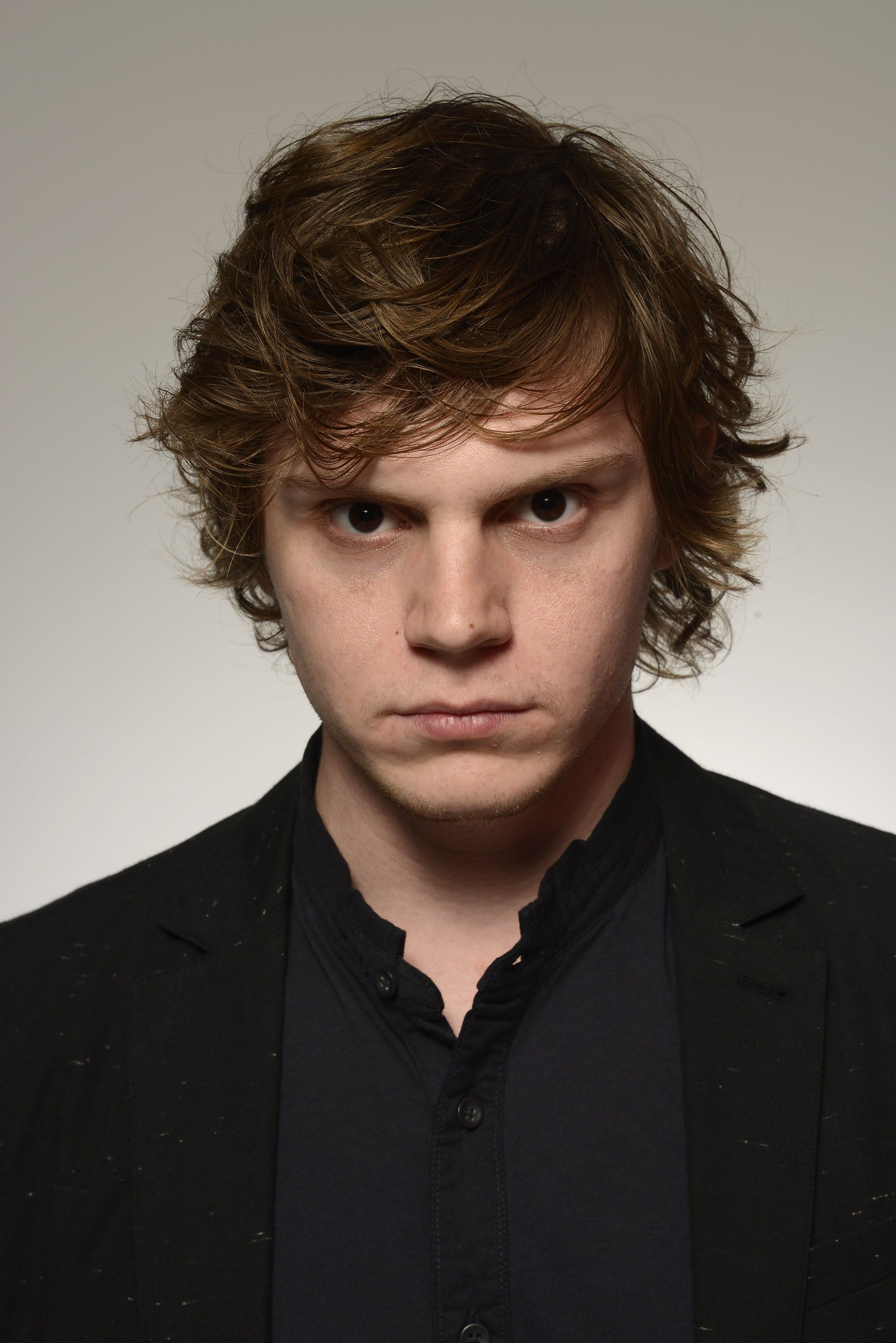 A young man with curly hair in black suit - Evan Peters