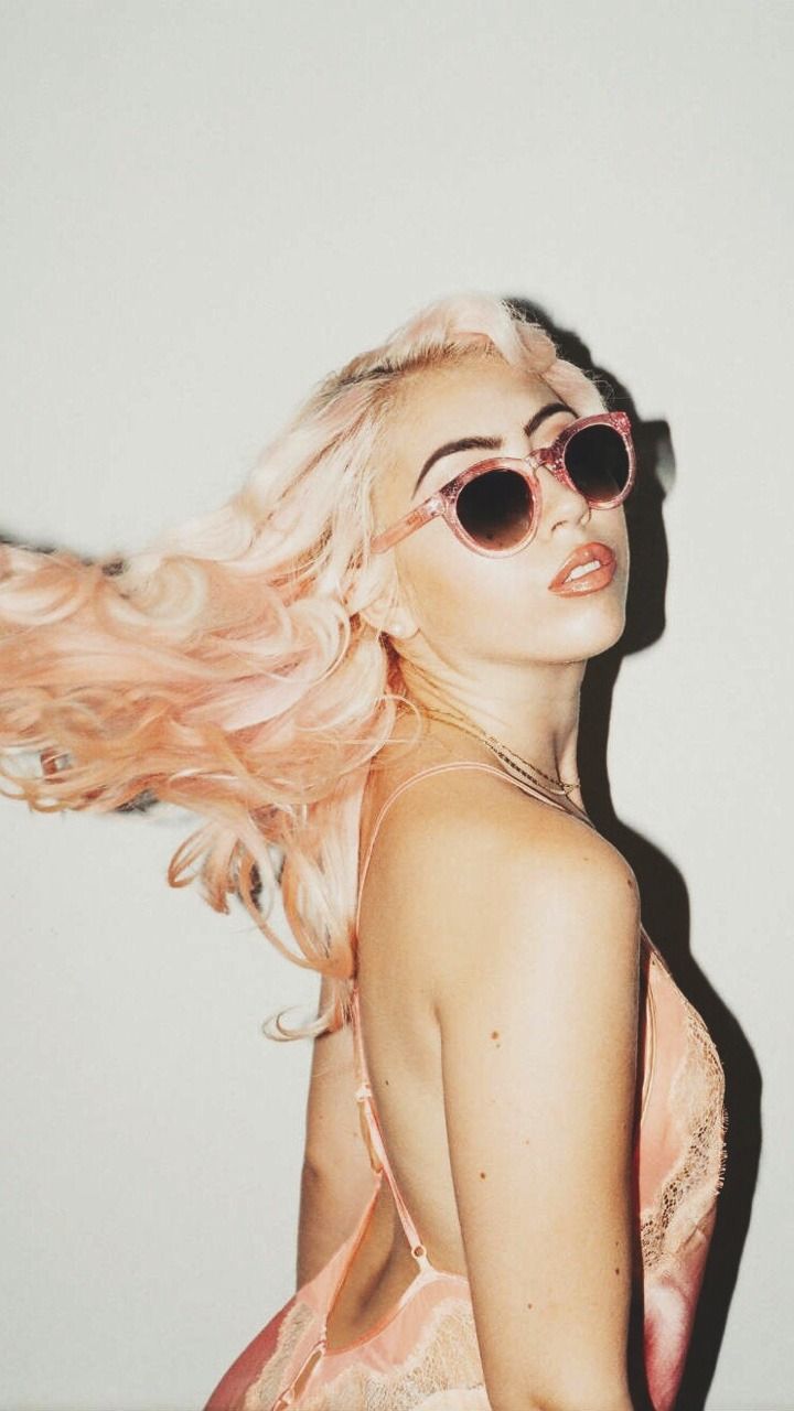 A woman in pink sunglasses with her hair blowing - Kali Uchis