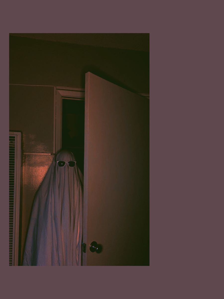 A ghostly figure peeks out from behind a door. - Ghost