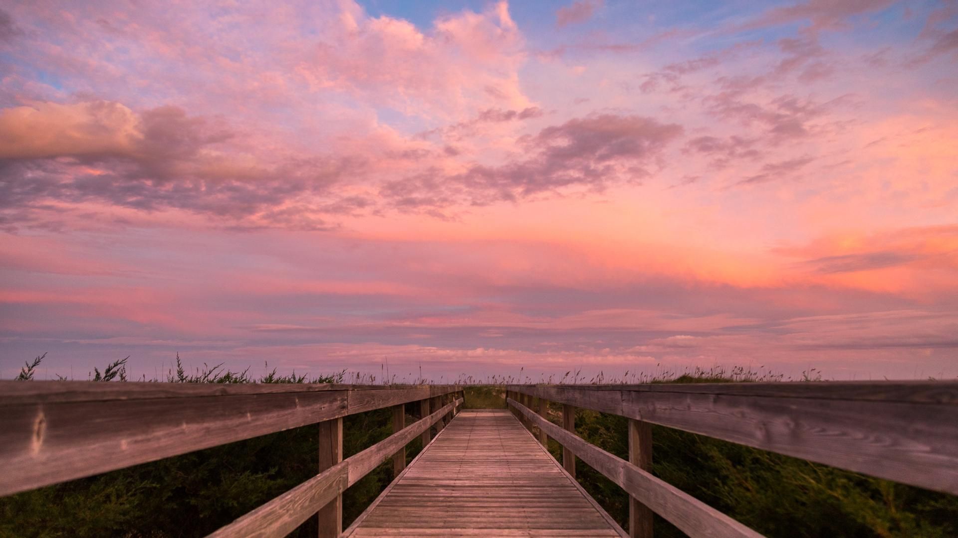 A wooden walkway leading to the beach - Sunset