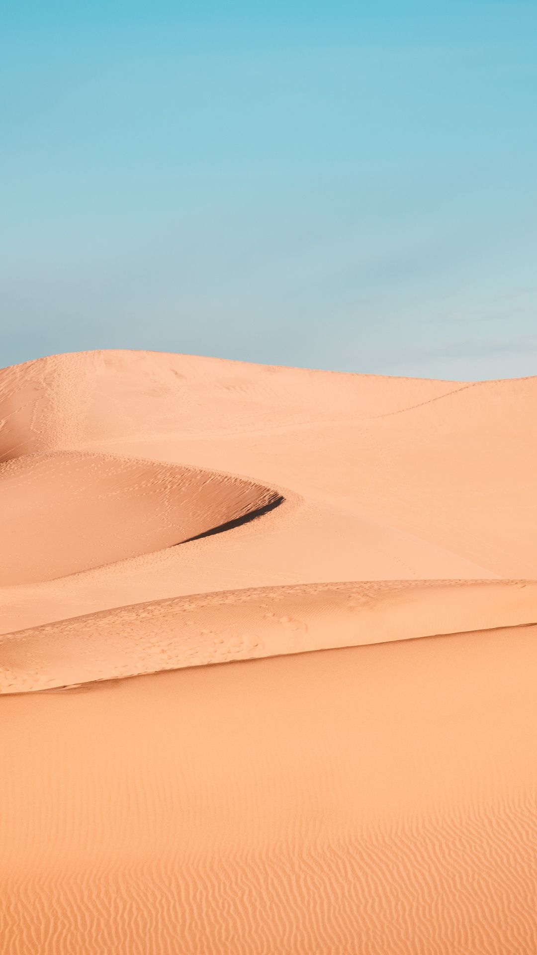 A man riding on top of sand dunes - Desert