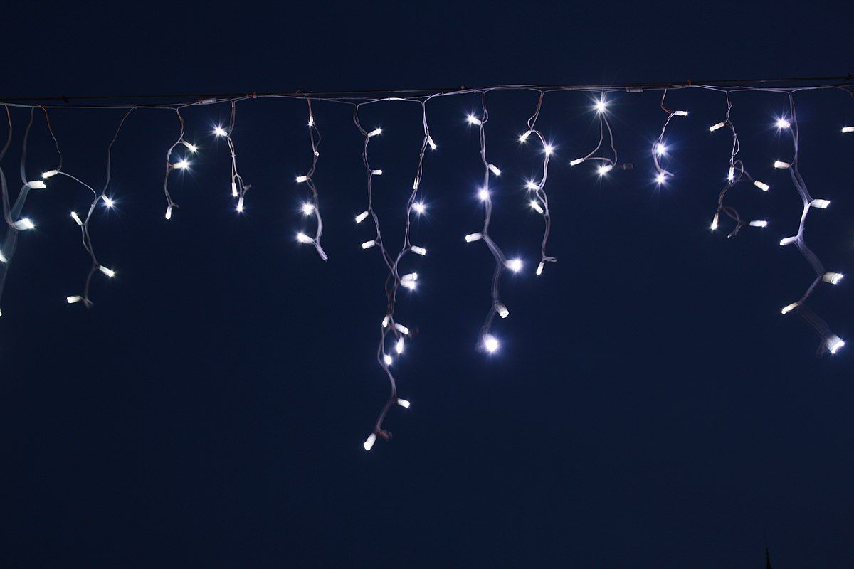 A string of white lights hanging from the ceiling - Christmas lights