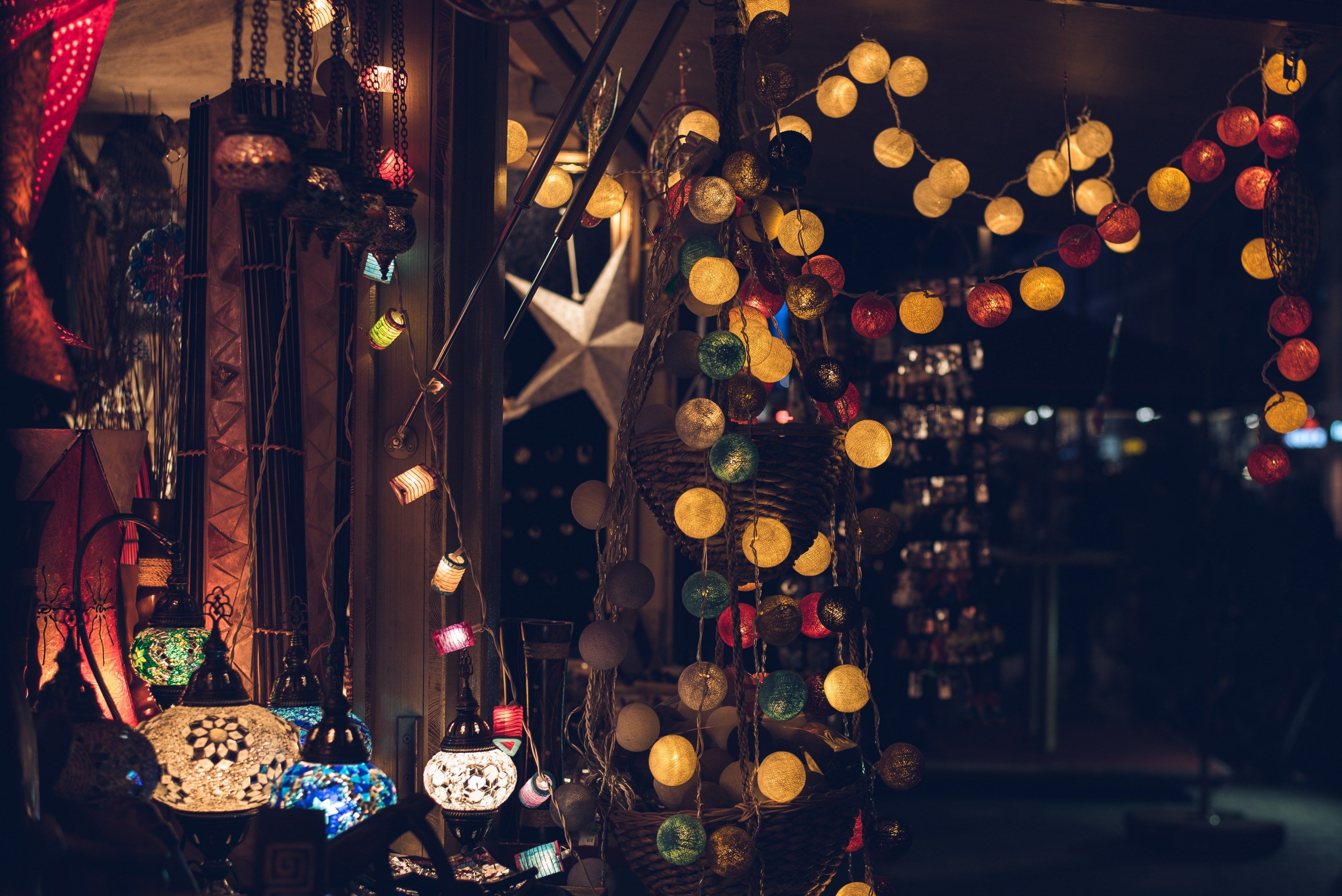 A market stall with lots of different hanging decorations - Christmas lights