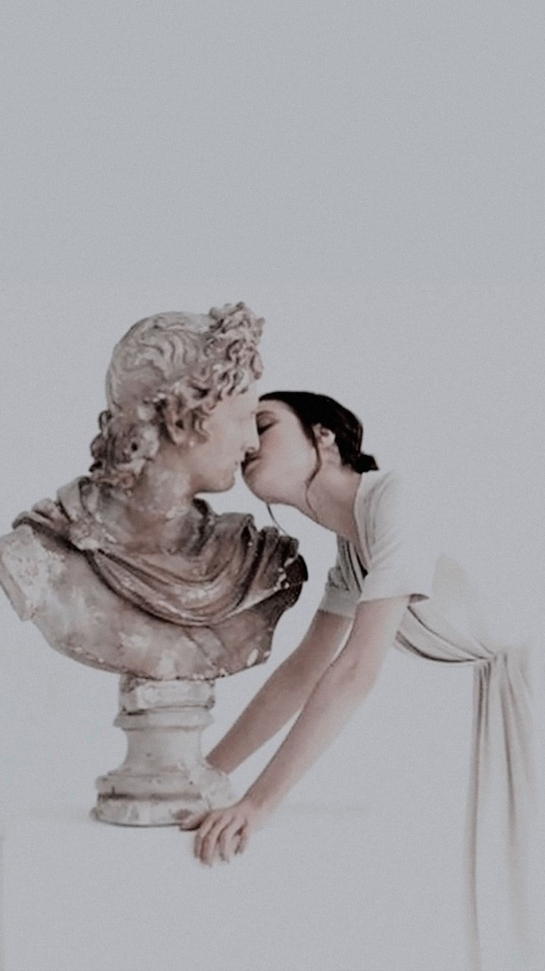 A woman kissing the head of an ancient statue - Greek mythology