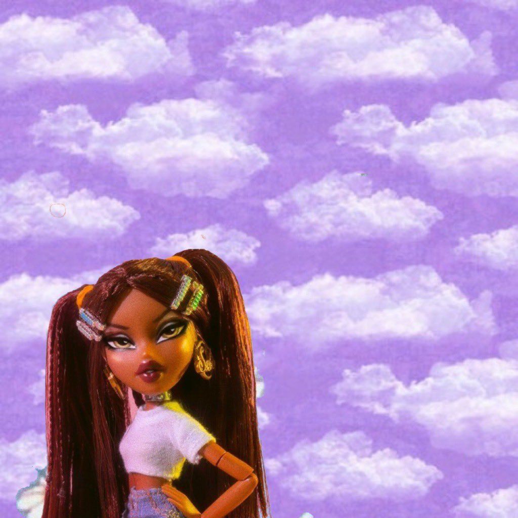 A doll with long brown hair and a white top stands in front of a purple sky with white clouds. - Bratz