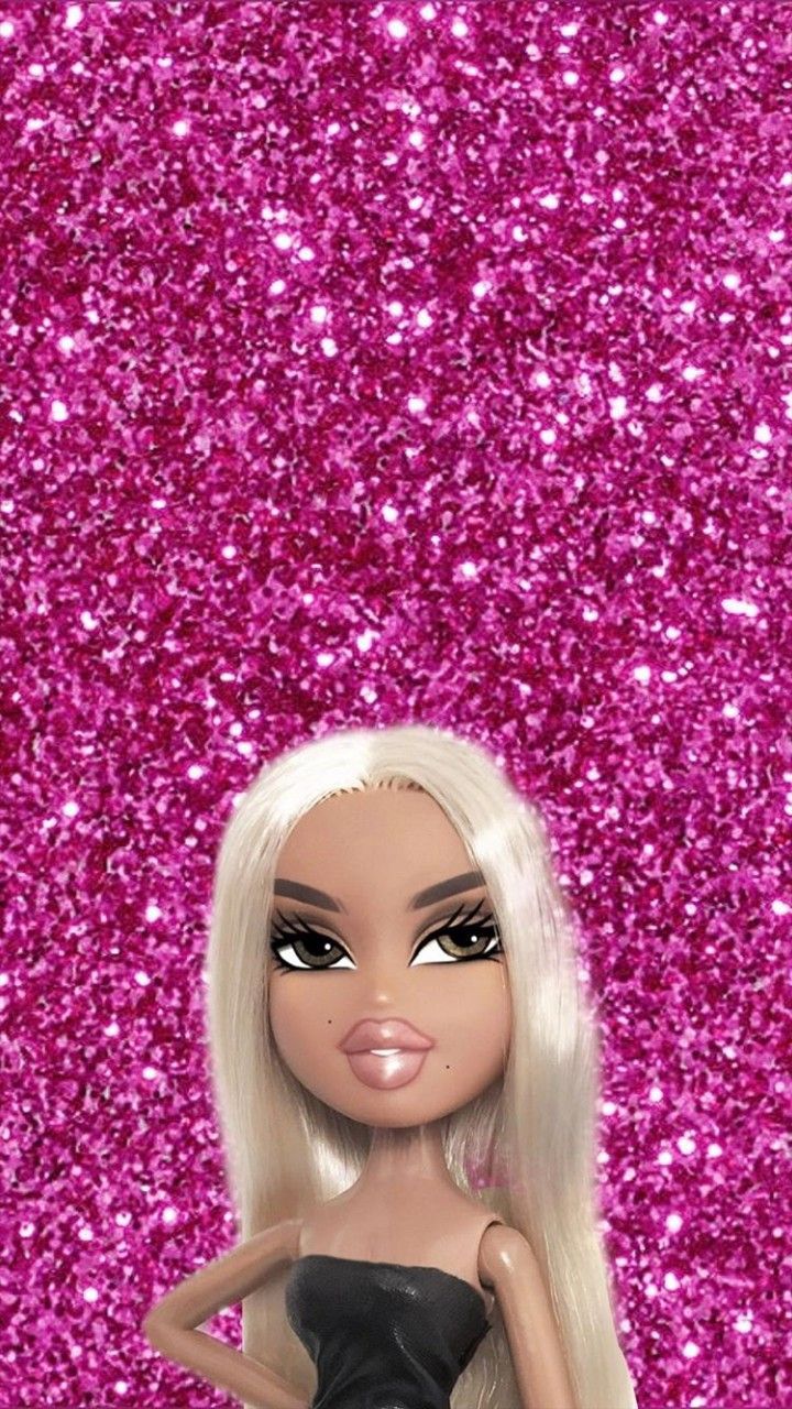A doll with blonde hair and black dress standing in front of pink glitter - Bratz
